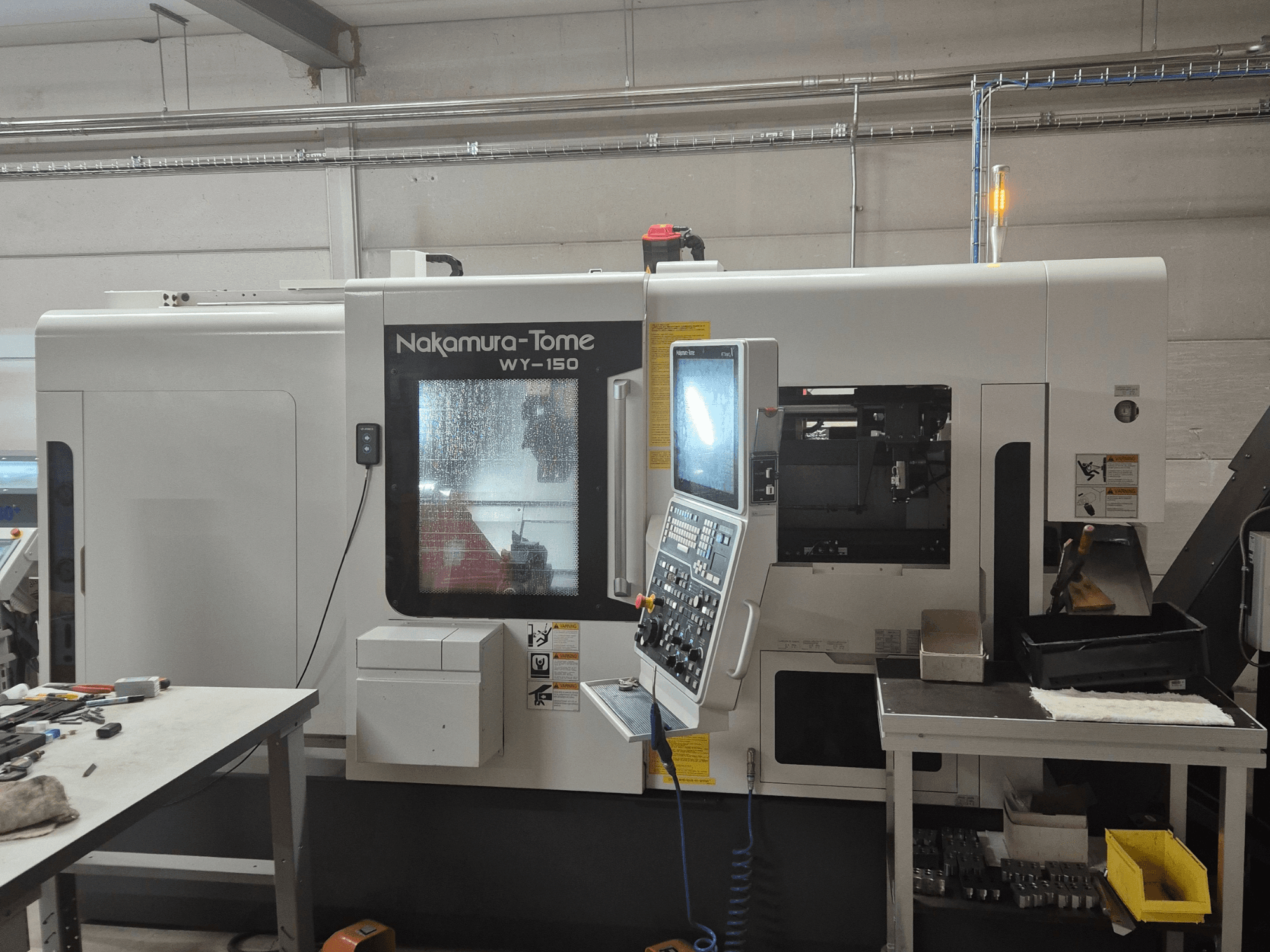 Nakamura-Tome WY-150 CNC-svarv i sidovy, med kontrollpanel, genomskinligt fönster och synligt arbetsområde.