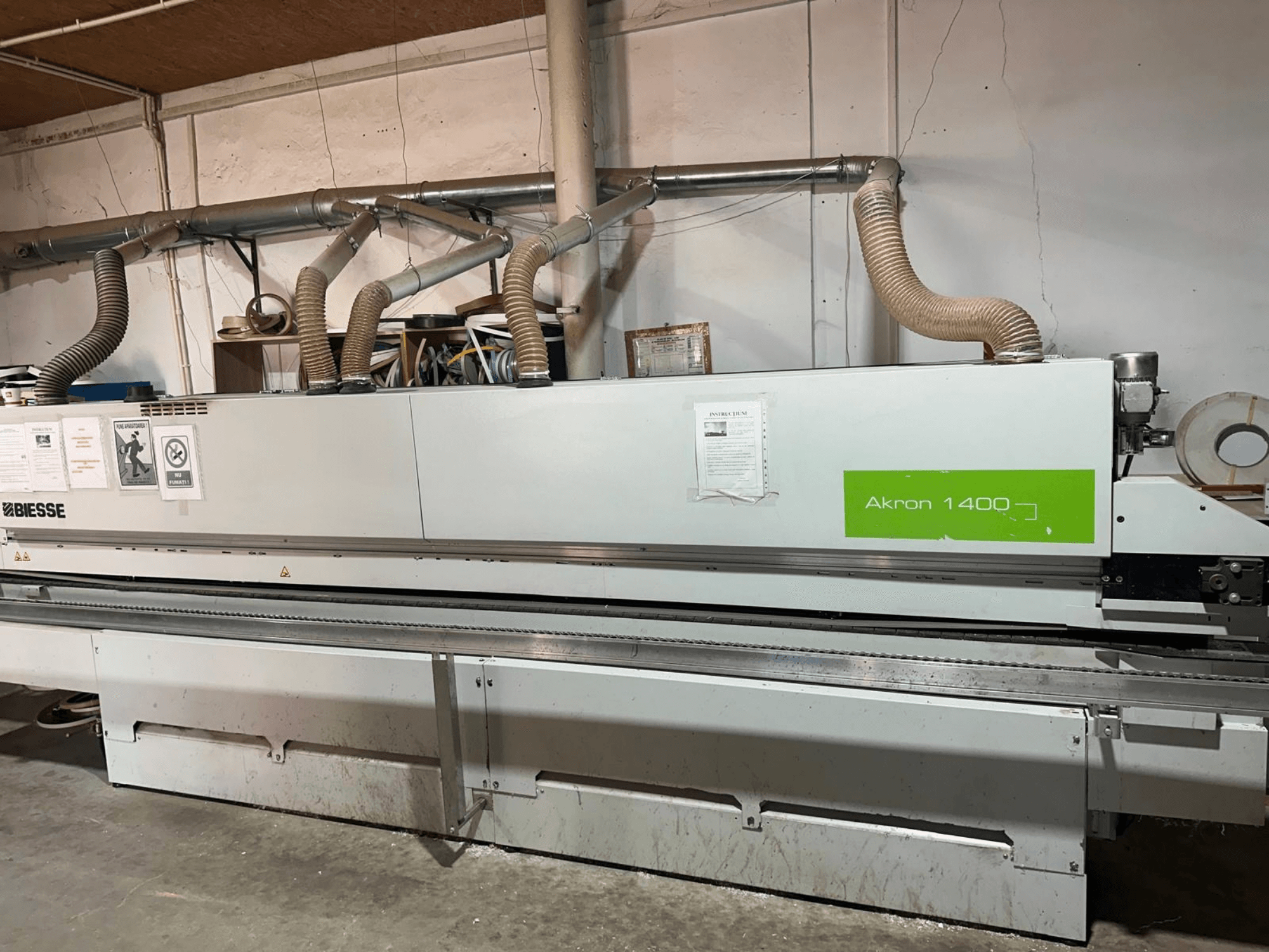 En BIESSE Akron 1440 A kantlistmaskin i sidovy, med luftkanaler, kontrollpanel och driftsdekaler.