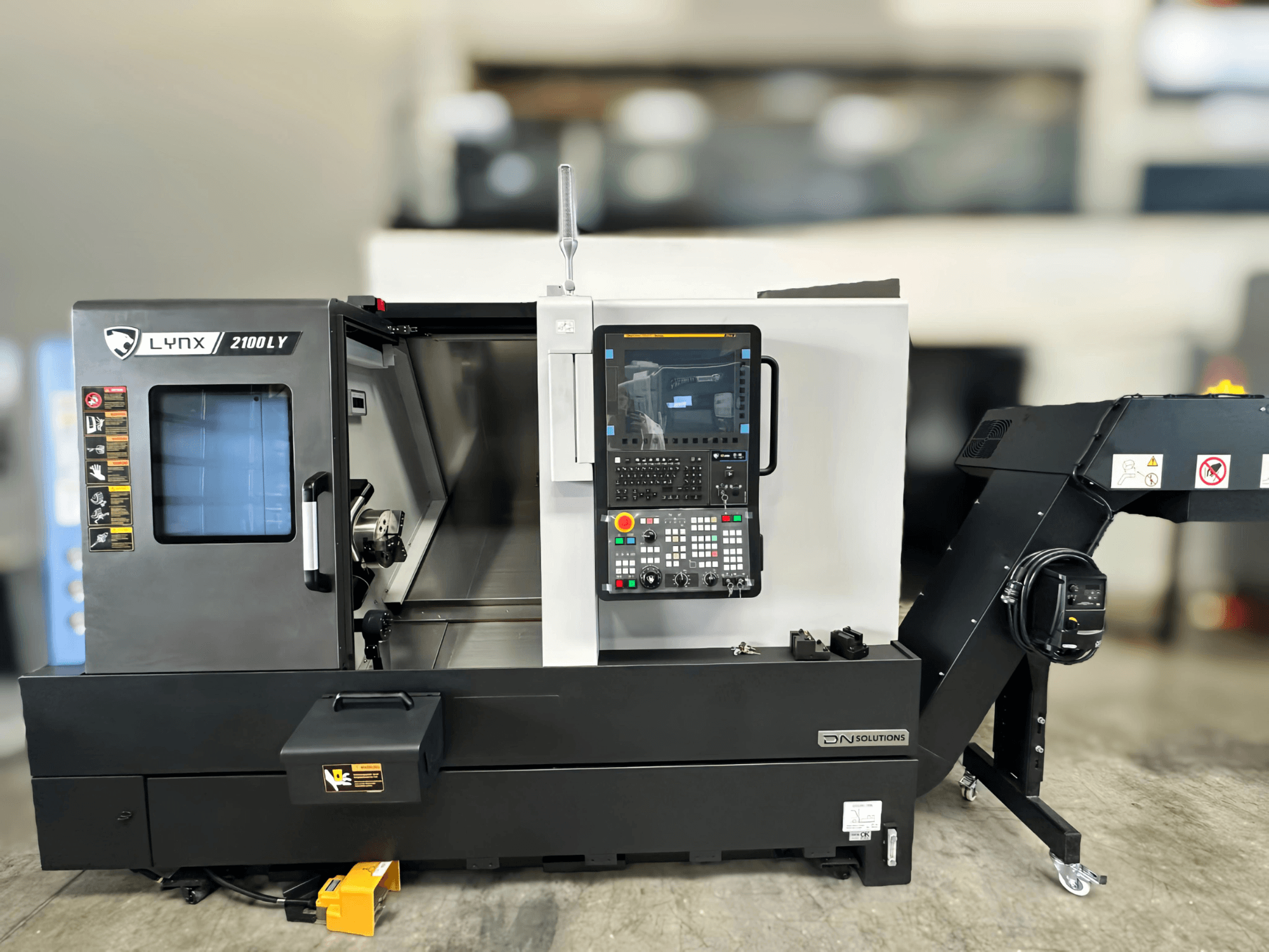 Horisontell svarv DN SOLUTIONS LYNX 2100LYB, framifrån, med kontrollpanel och öppen dörr som avslöjar interiören.