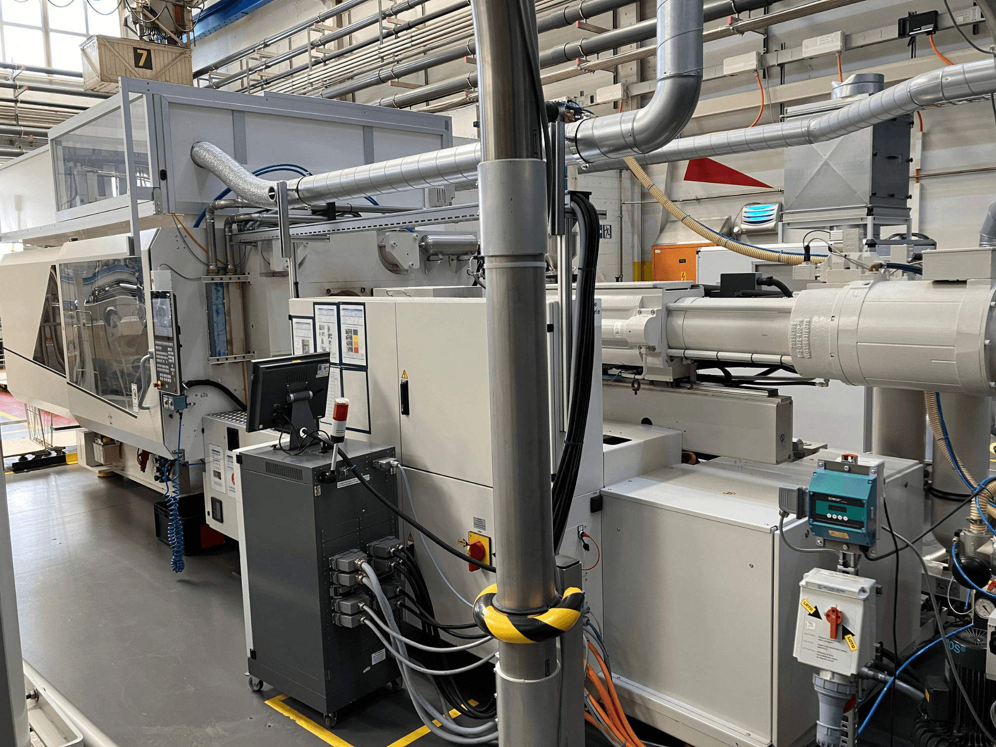 Industrimaskin med kontrollpanel, framifrån, med rör, elektriska komponenter och säkerhetsfunktioner.