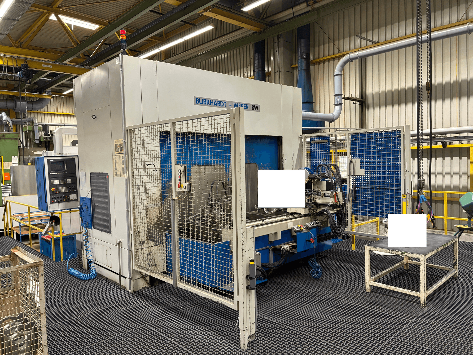 Burkhardt + Weber BW bearbetningscenter, framifrån, med kontrollpanel och säkerhetsskåp, placerad i industriell miljö.