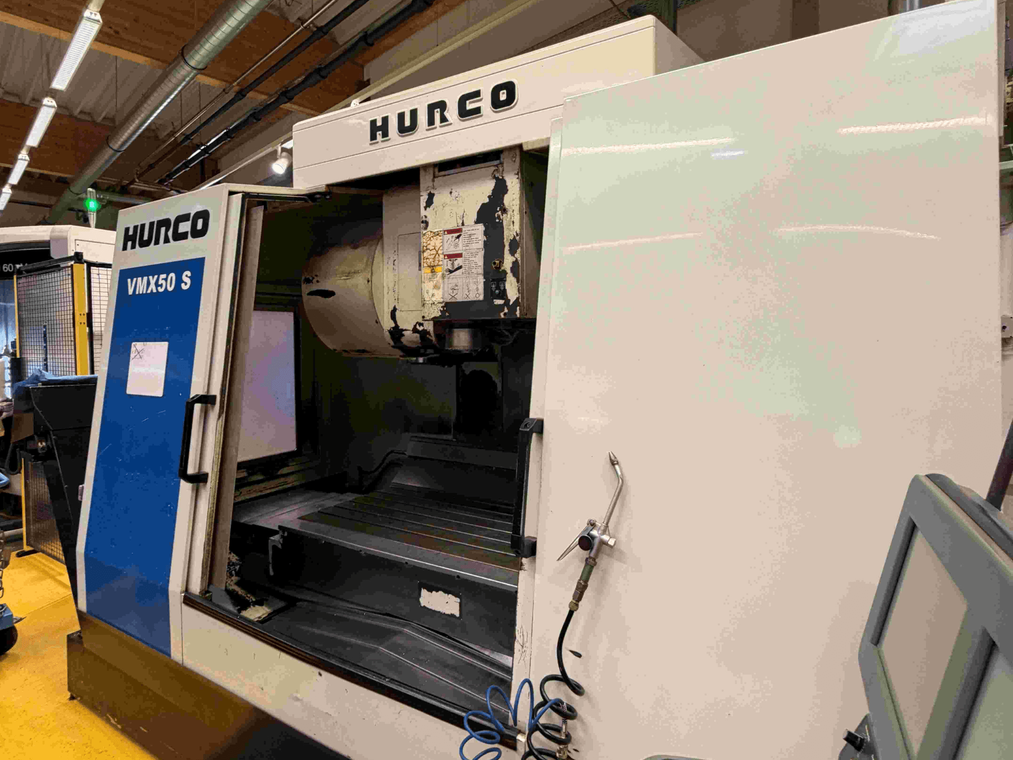 Hurco VMX50 S vertikal fleroperationsmaskin, vy från sidan, med öppen dörr och kontrollpanel.