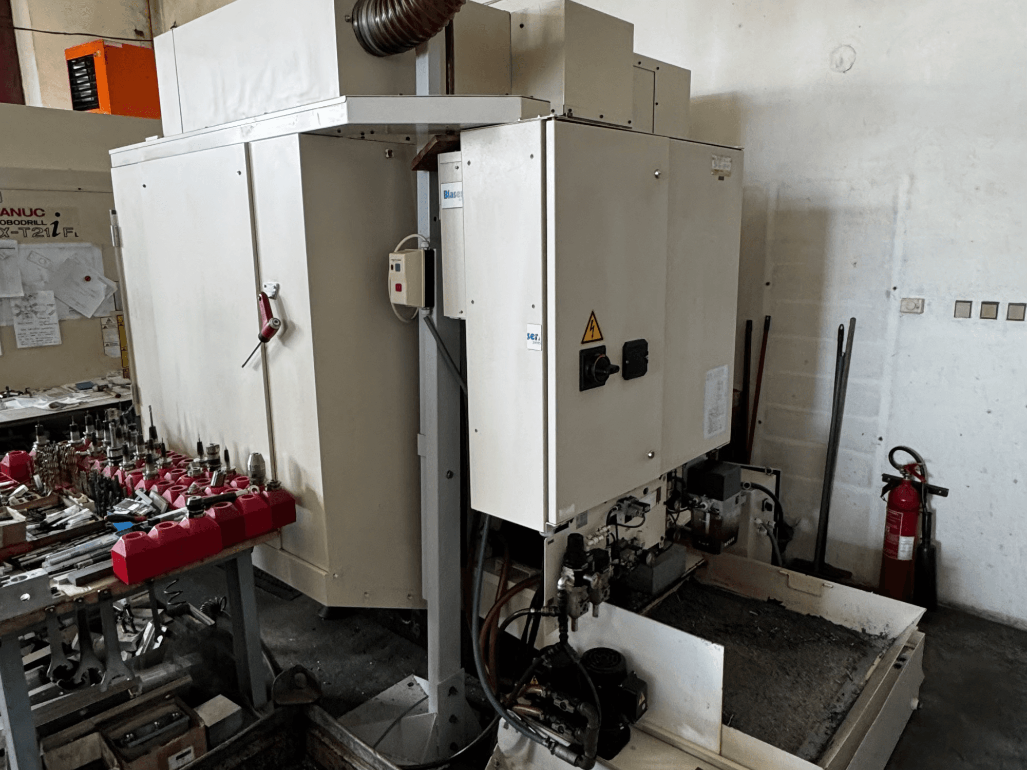 FANUC Robodrill alpha-T21iFL vertikal bearbetningscenter, sidovy som visar kontrollpanel, verktyg och arbetsyta.