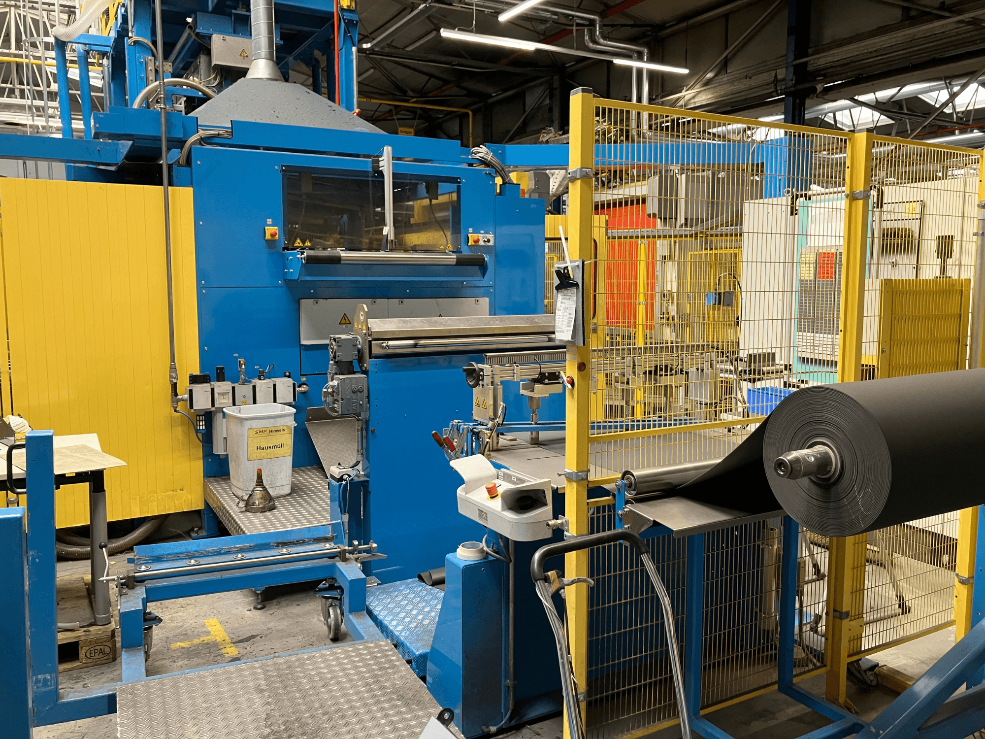 KIEFEL KLS 86/235 plastbearbetningsmaskin sedd framifrån, med en rulle med svart material och kontrollpanel.