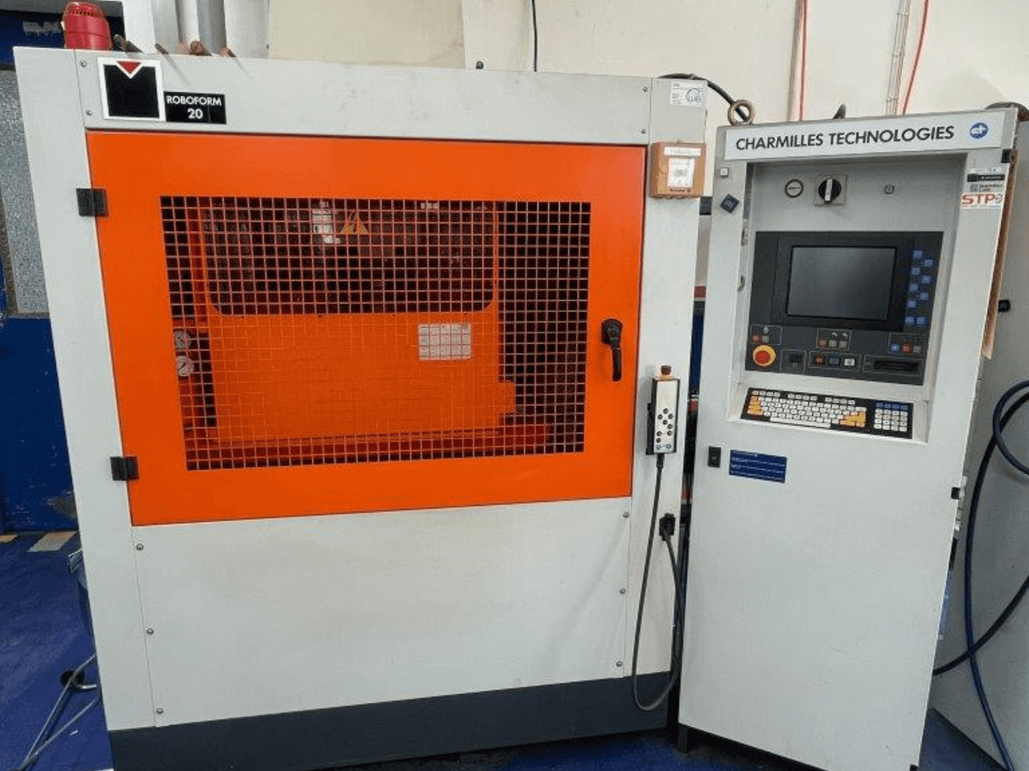 AgieCharmilles Robofrom 20 sänkgnistmaskin, framifrån med kontrollpanel och orange skyddsgaller.