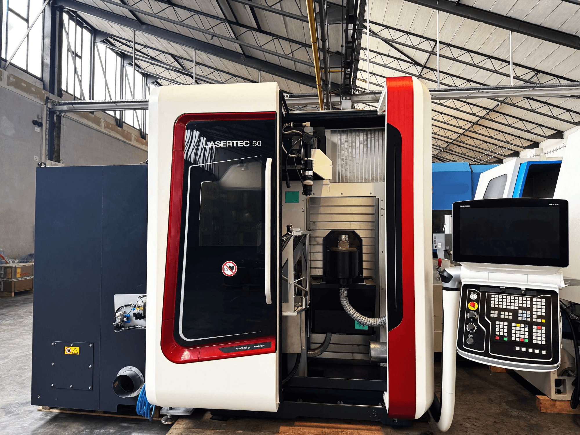 LaserTec 50 CNC-maskin i sidovy, med svartvit kontrollpanel, synlig verktygshållare och industriell miljö.