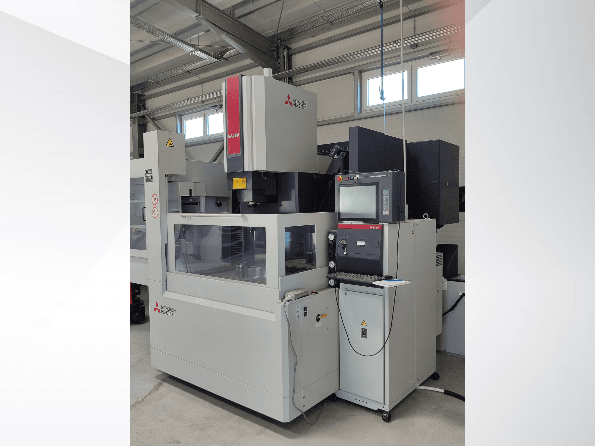 Mitsubishi Electric EA32V trådgnistmaskin i sidovy, med kontrollpanel och synligt arbetsområde genom glas.