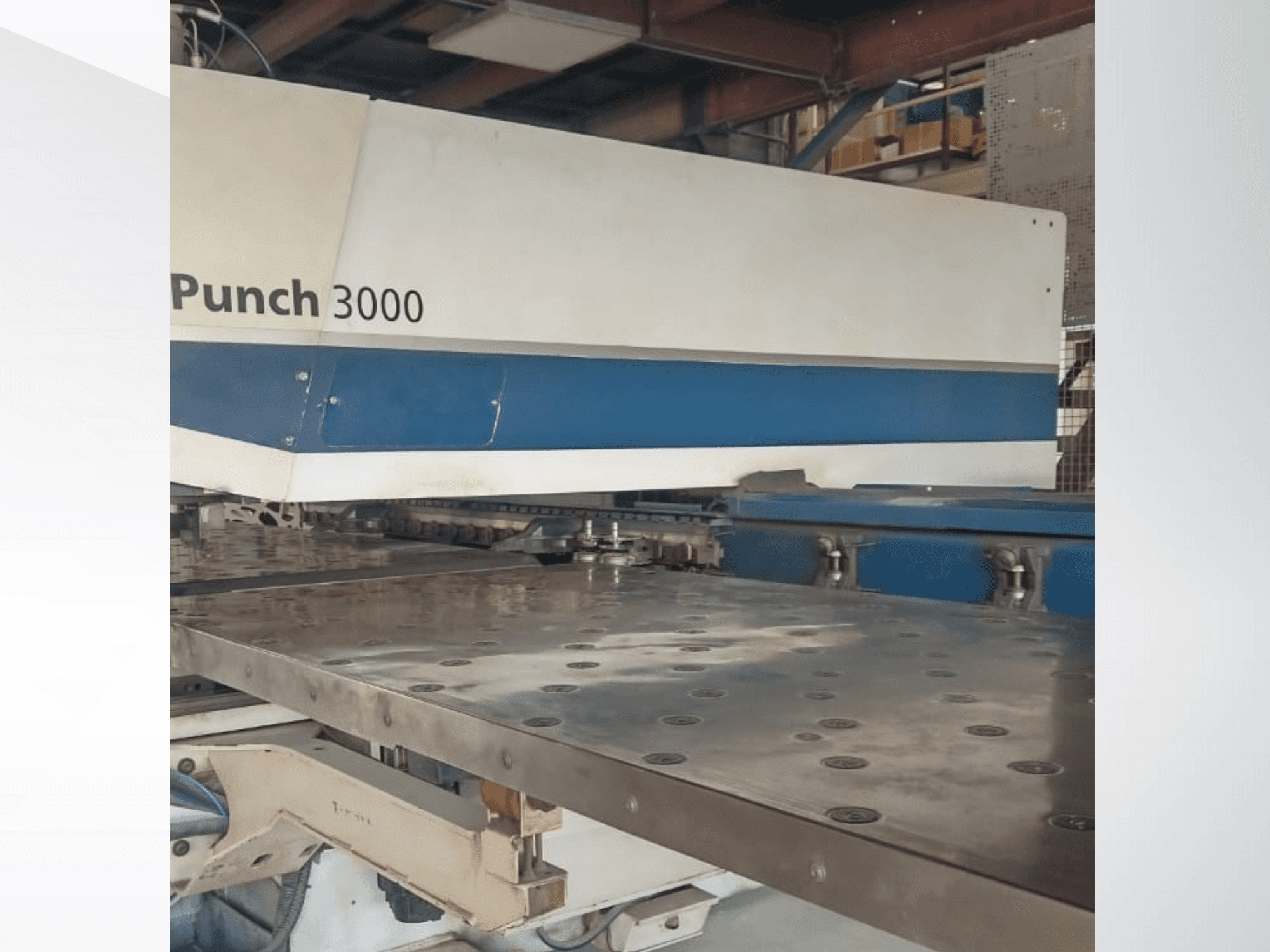 Punch 3000-maskin i en verkstad, vy framifrån, visar en stor, plan metallyta med flera stanshål.