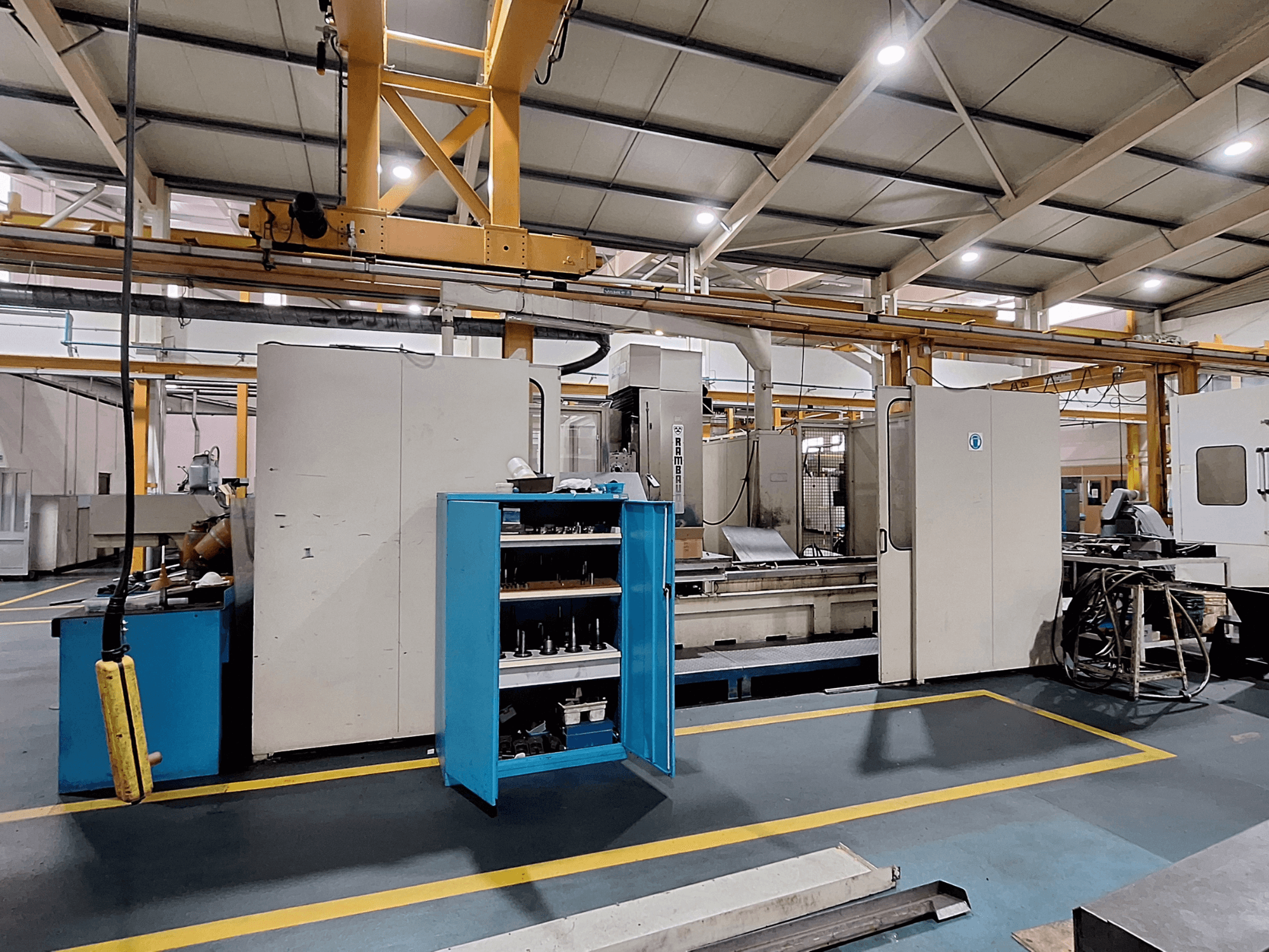 Portalfräsmaskin Rambaudi RX 1250, framifrån med verktygsförvaring, i ett rymligt industriellt arbetsutrymme.