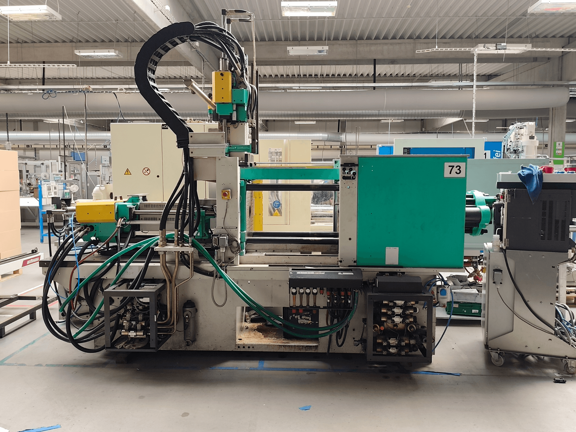 Hydraulisk formsprutningsmaskin, Arburg 420 C 1000-150/60, sidovy, med synliga hydrauliska anslutningar och manöverreglage.