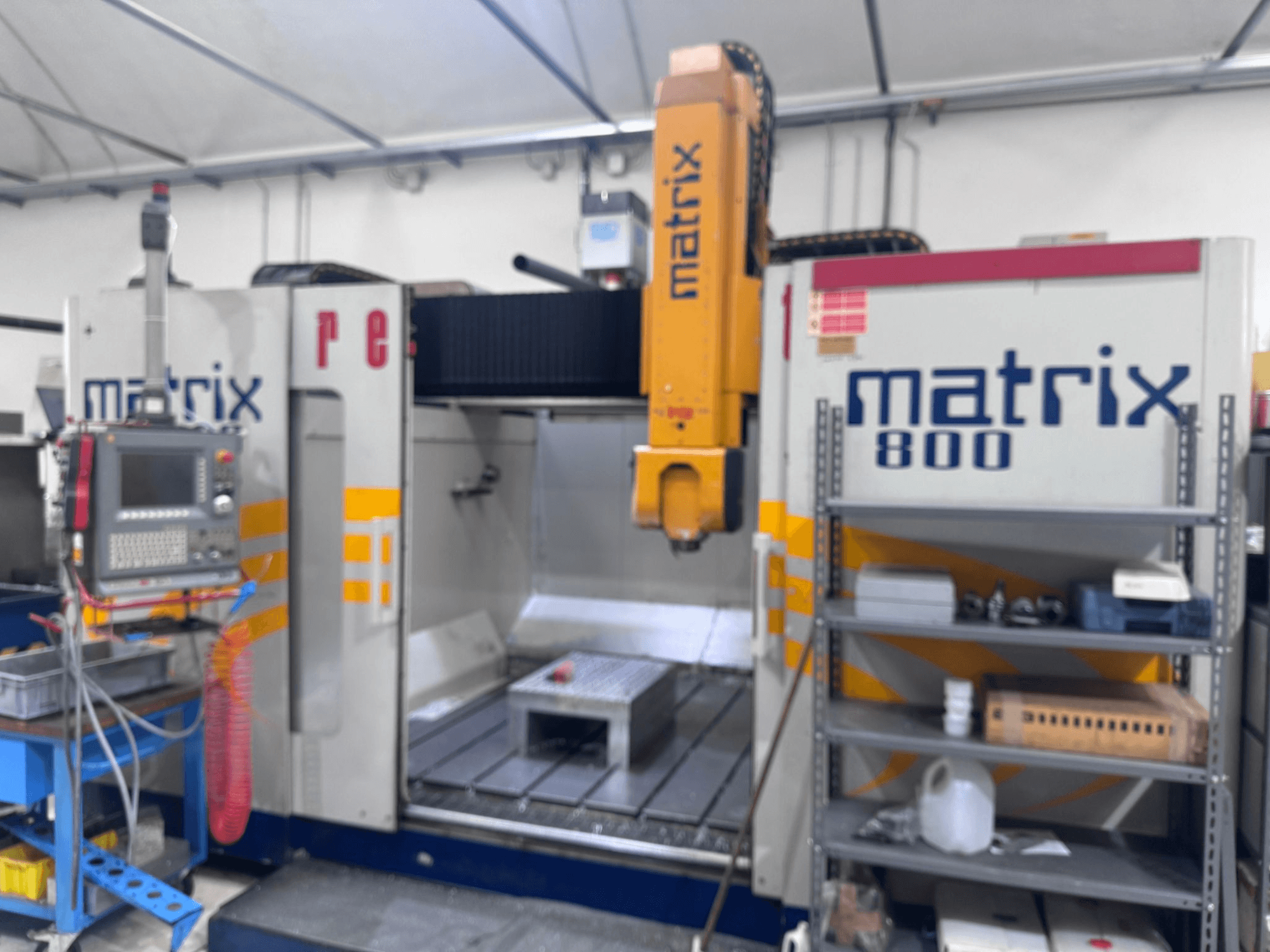 CNC-maskin Matrix 800 i verkstadsvy med kontrollpanel, verktyg och arbetsbord med olika föremål.