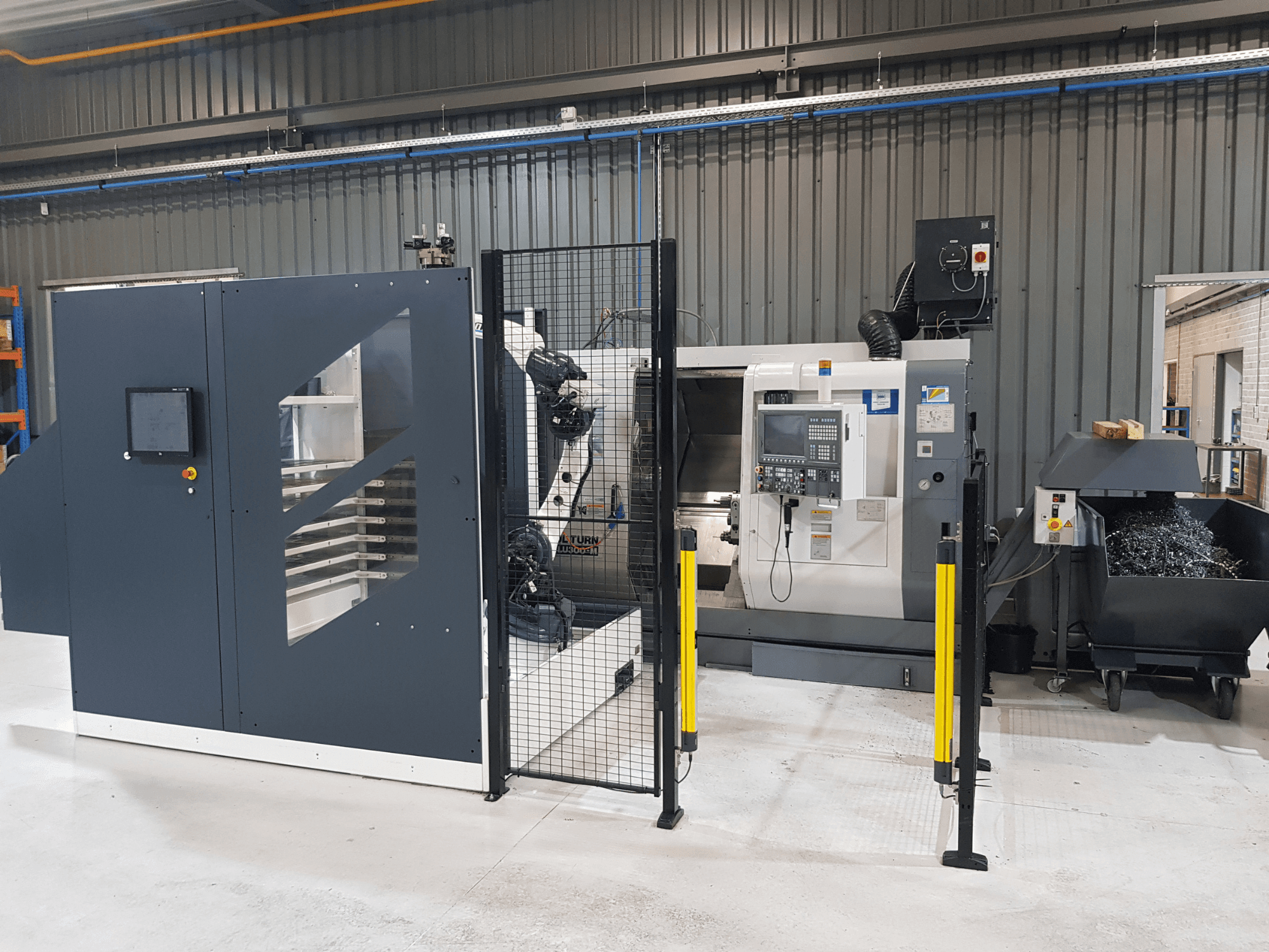 ALTURN automatiserad svarv och CNC-maskin i fabriksmiljö; framifrån med kontrollpanel och säkerhetsstängsel synliga.