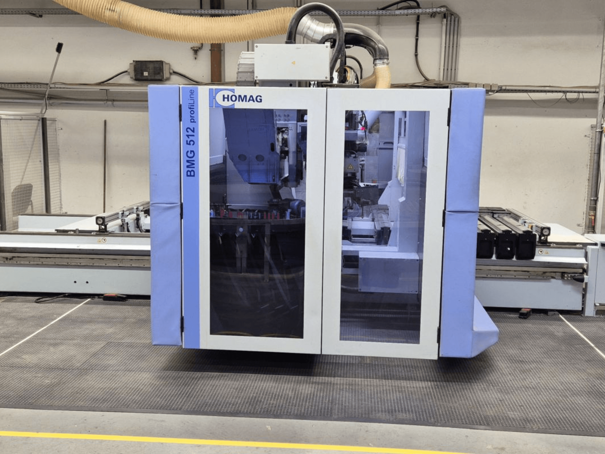 HOMAG BMG 512 ProfiLine CNC-maskin, framifrån, med glaspanel, synliga precisionsverktyg och industrimiljö.