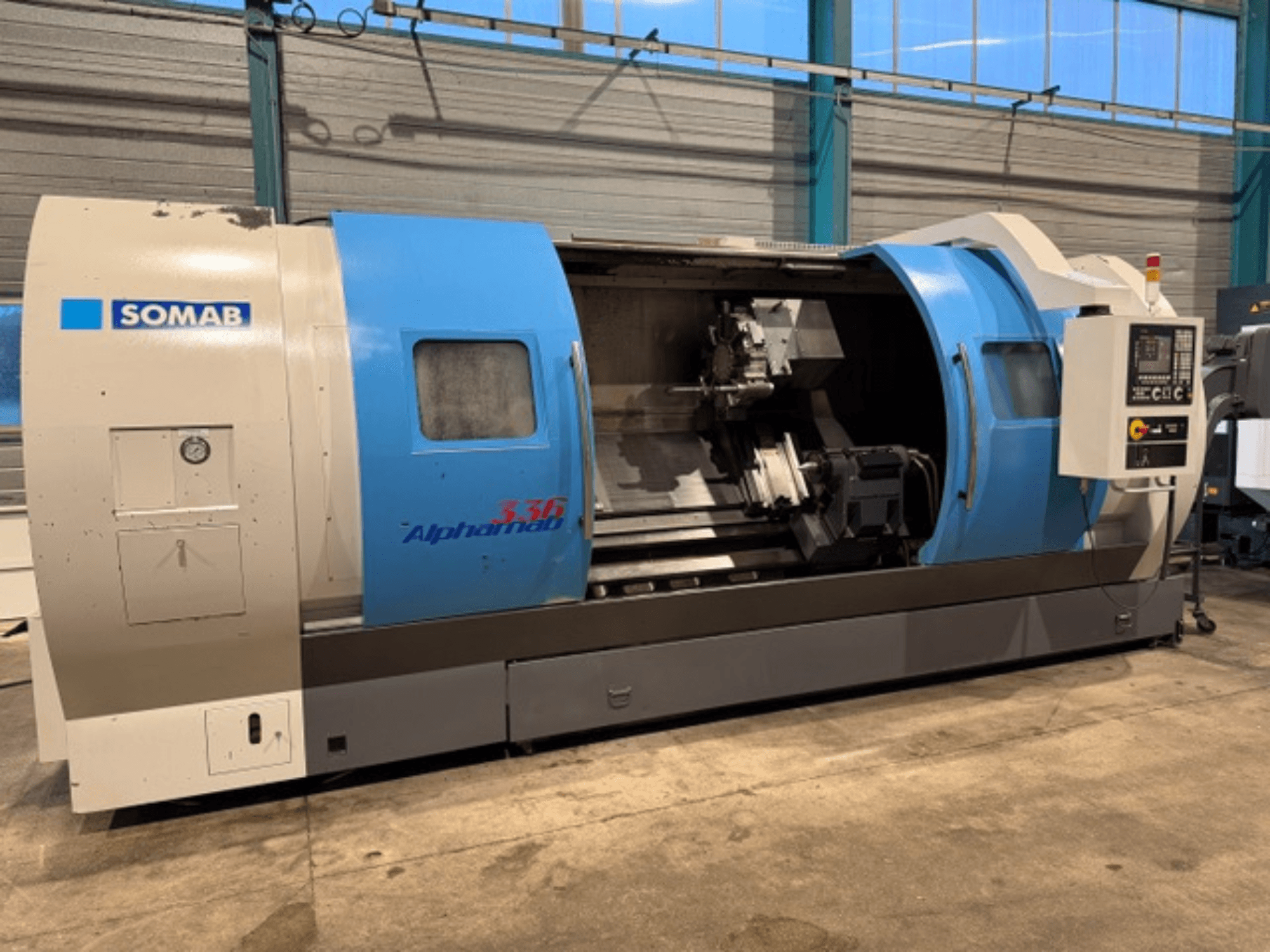 SOMAB Alpha 336 CNC-svarv, framifrån, med blått och grått hölje och en kontrollpanel på sidan för manövrering.
