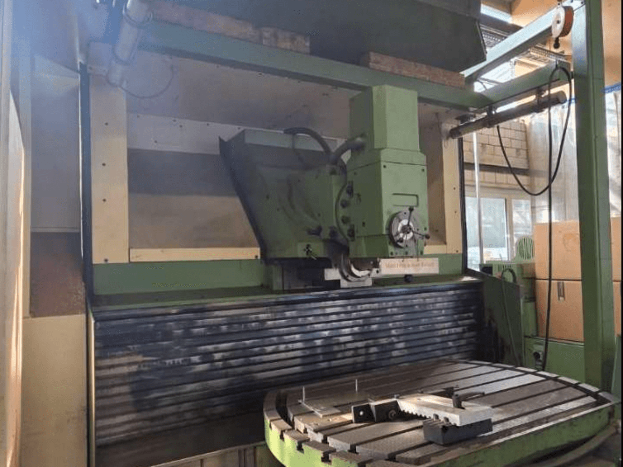 MAHO MH1000 C Universalbearbetningscenter framifrån, med grönstruktur, spindel och roterande bord med ett arbetsstycke.