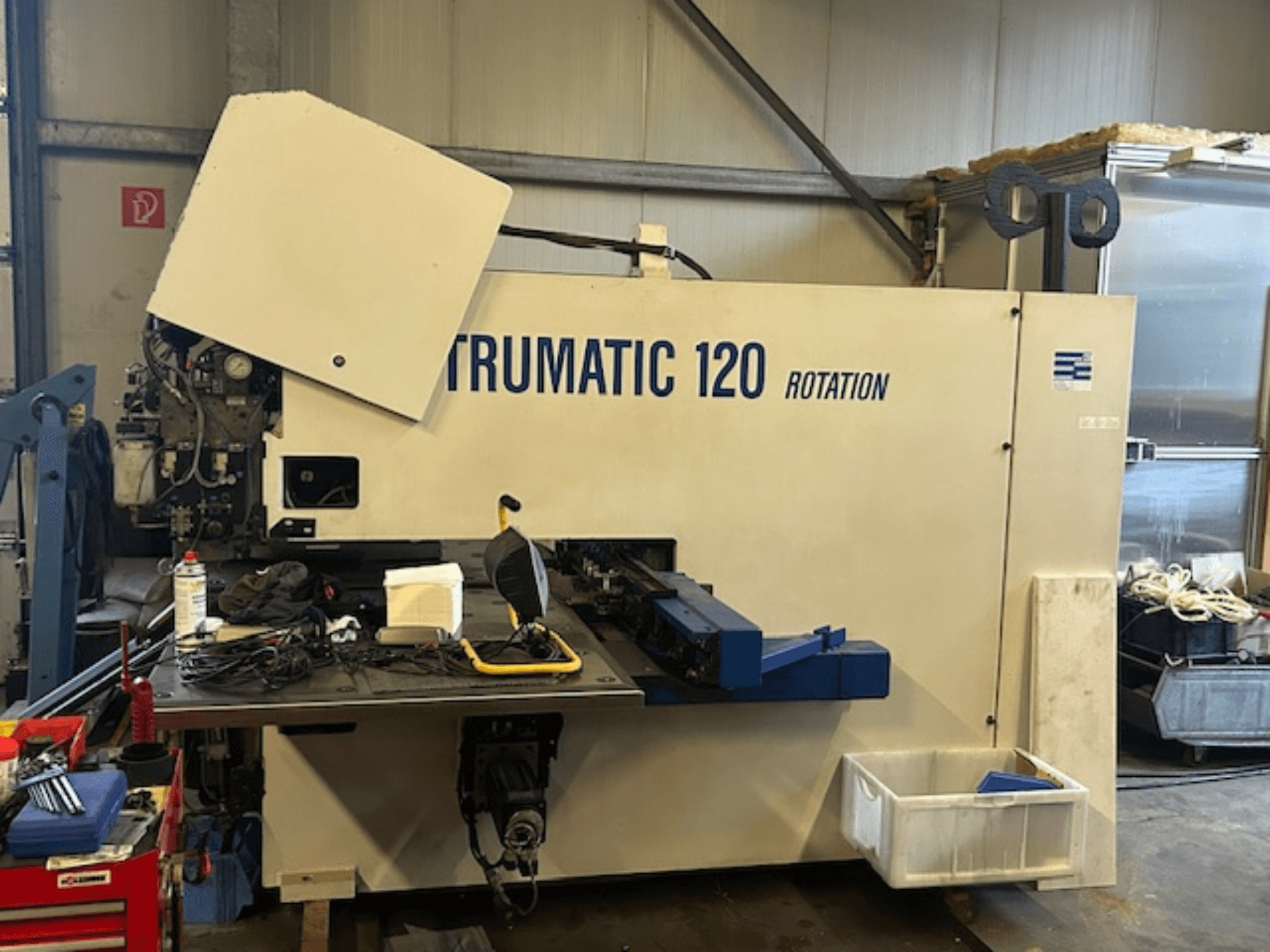 TRUMPF Trumatic 120R CNC-stansmaskin i en verkstad, framifrån med kontrollpanel och verktyg på bordet.