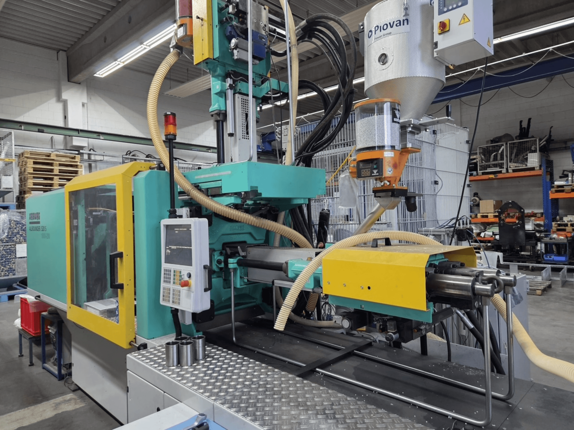 Hydraulisk formsprutningsmaskin Arburg Allrounder 520 S 1600-290, framifrån, med kontrollpanel och materialmatare synliga.