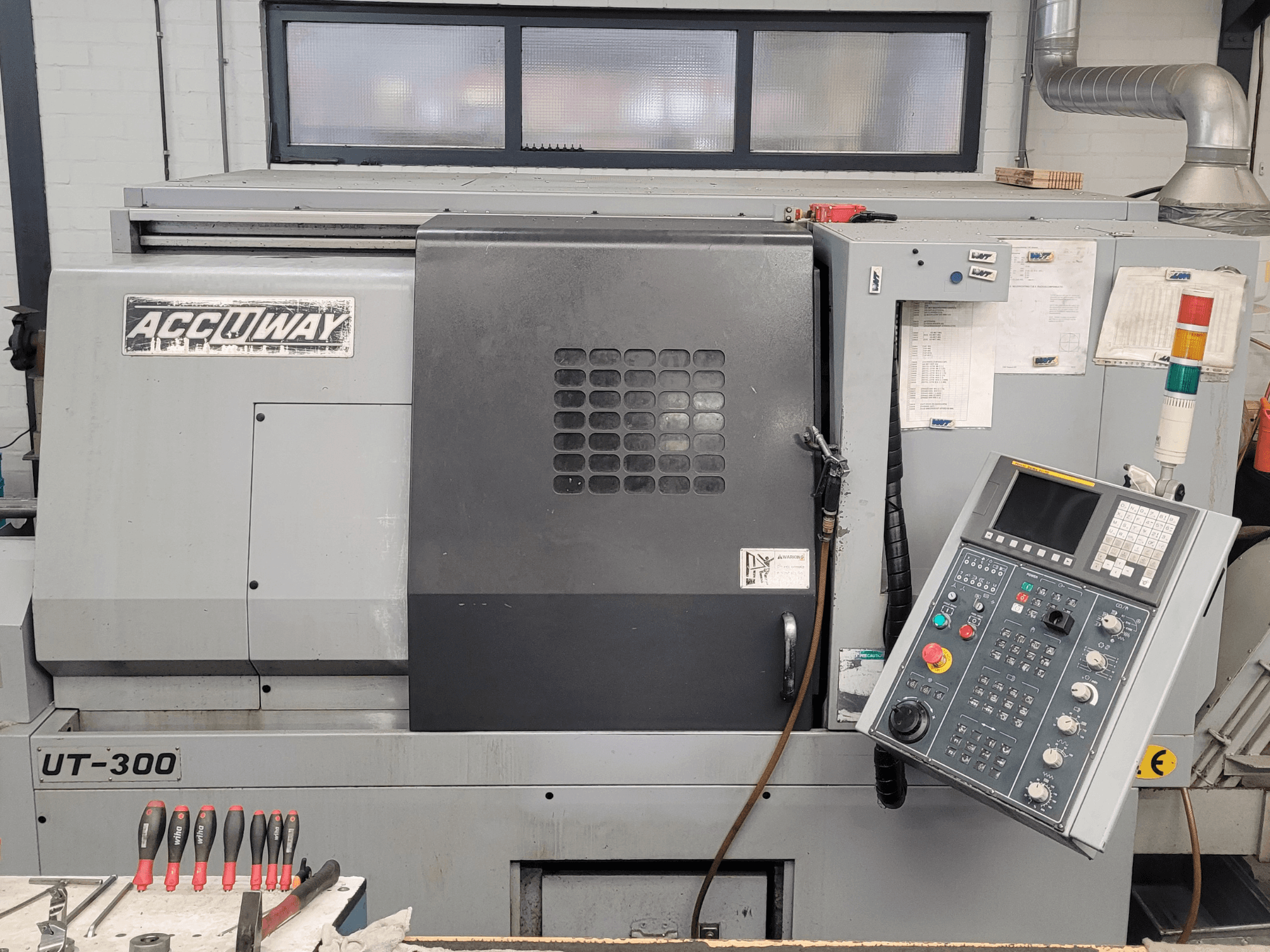Accuway UT-300 CNC-maskin framifrån, med kontrollpanel och olika manöverknappar, i en verkstadsmiljö.