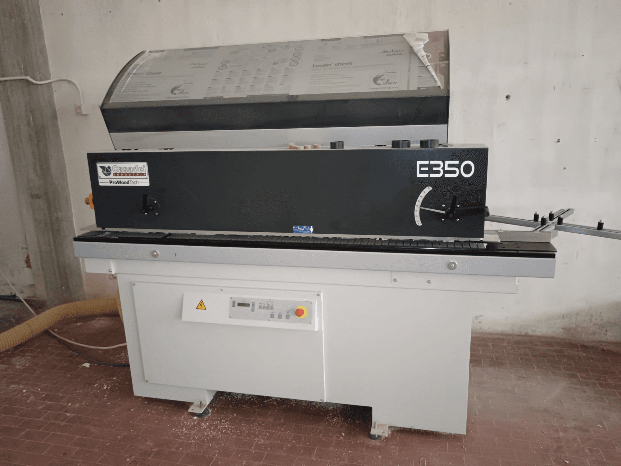 Cesaroli ProWoodtech E350, sidovy av en träbearbetningsmaskin med kontrollpanel och dammuppsamling, monterad på en vit bas.