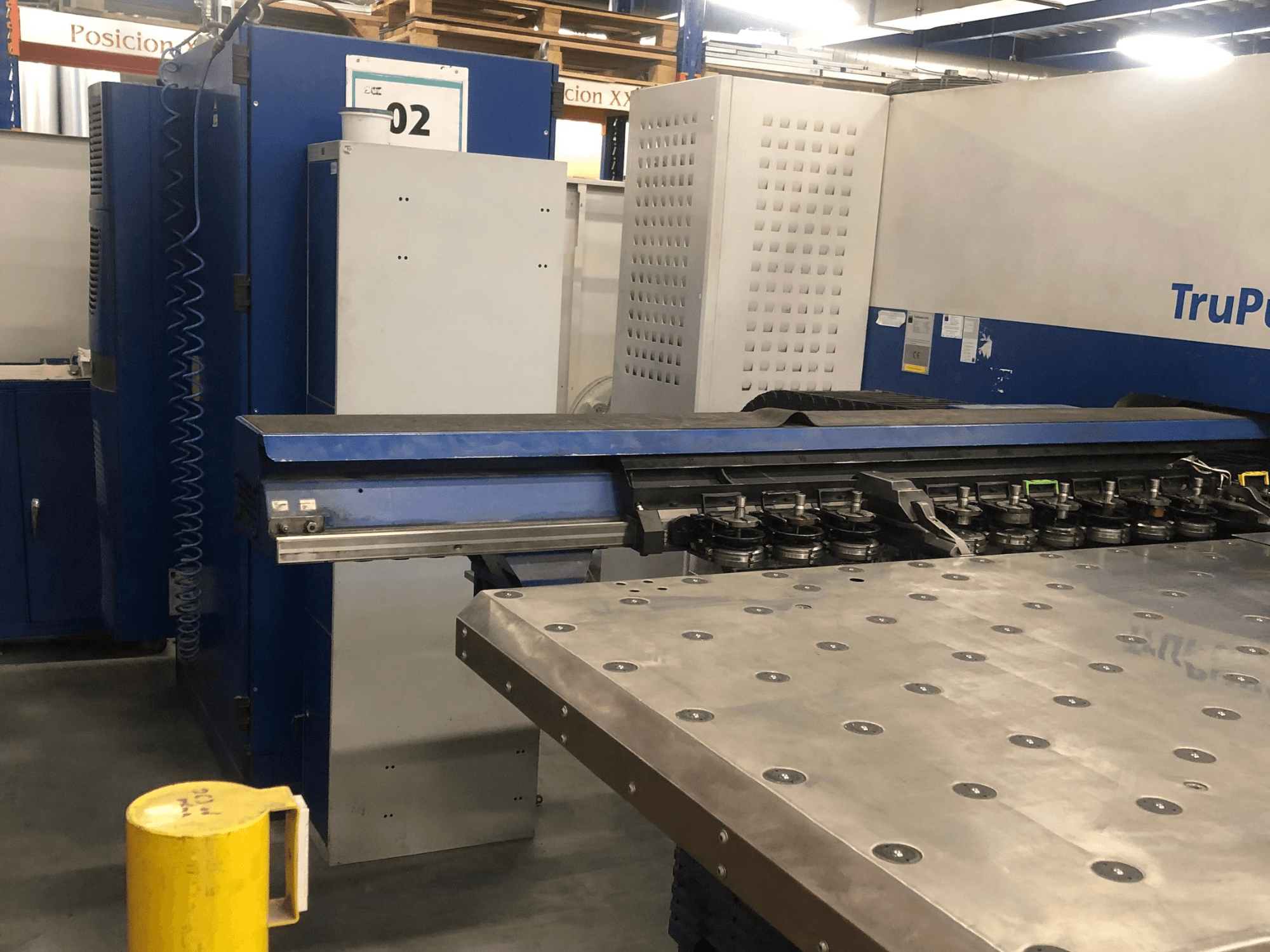 TRUMPF TruPunch 5000 CNC-stansmaskin, framifrån sett med verktygsrevolver och kontrollpanel, med ett arbetsbord av metall intill.