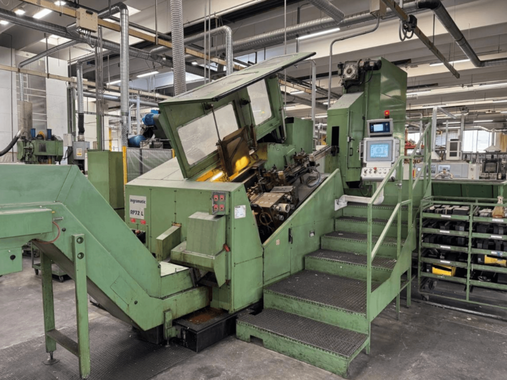 Ingramatic RP72 L, industrimaskin i grönt, framifrån; har en kontrollpanel och steg med en plattform av metallgaller.