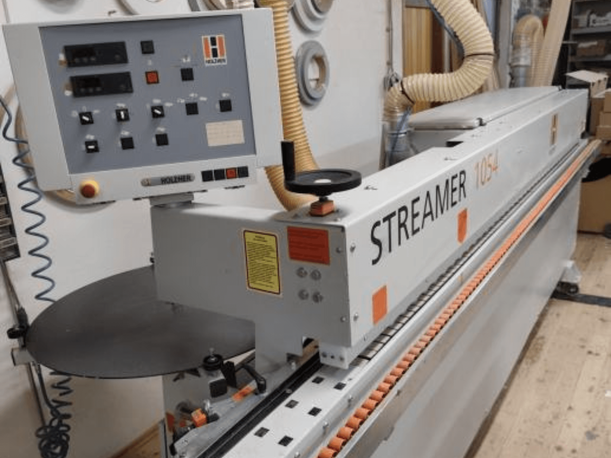 HOLZHER Streamer 1054 kantlistmaskin, sidovy som visar manöverpanel och matningssystem på en verkstadsbakgrund.