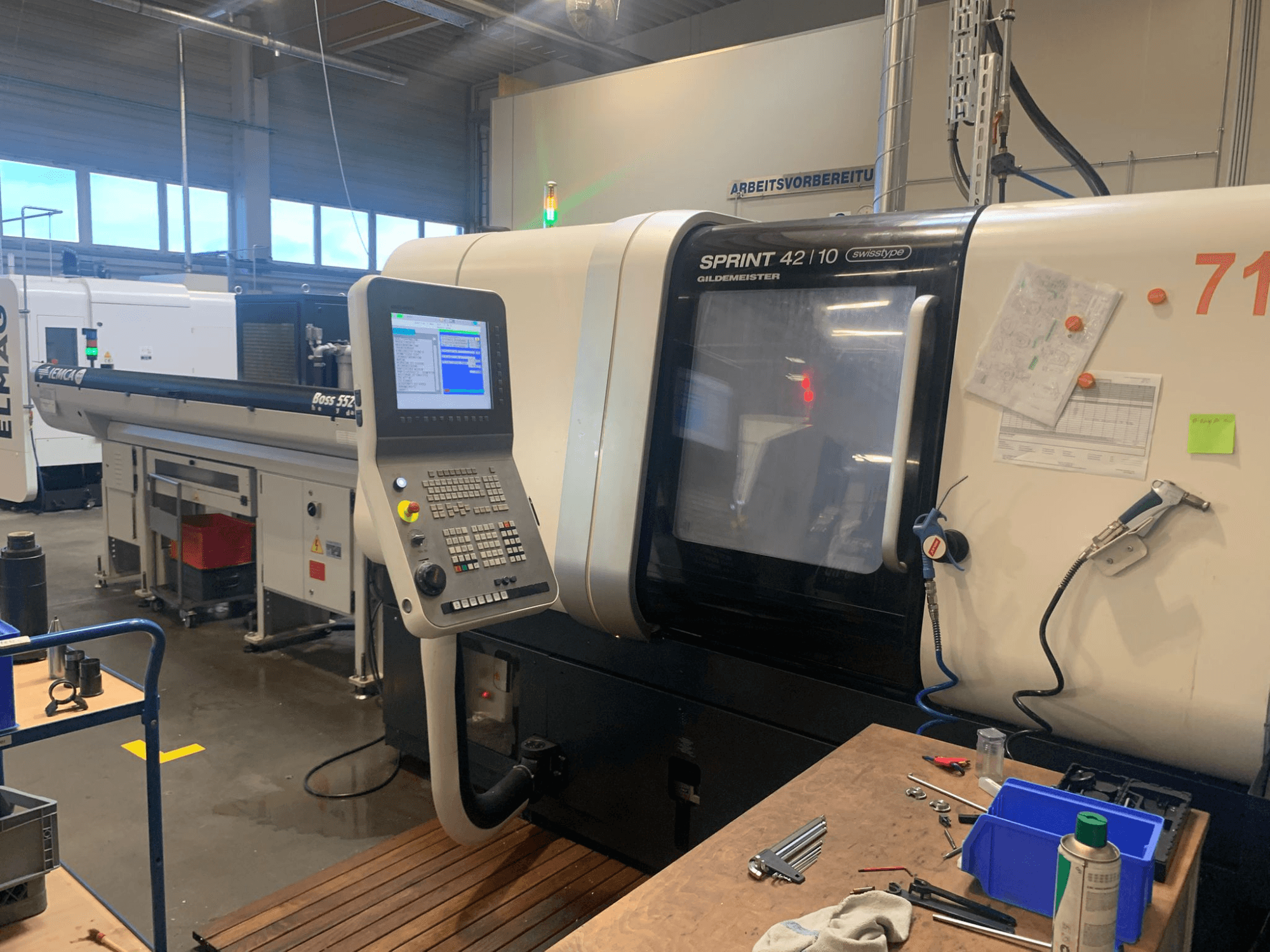 DMG MORI Sprint 42/10 linjär svarv av schweizisk typ, framifrån, med kontrollpanel och rörigt arbetsutrymme.