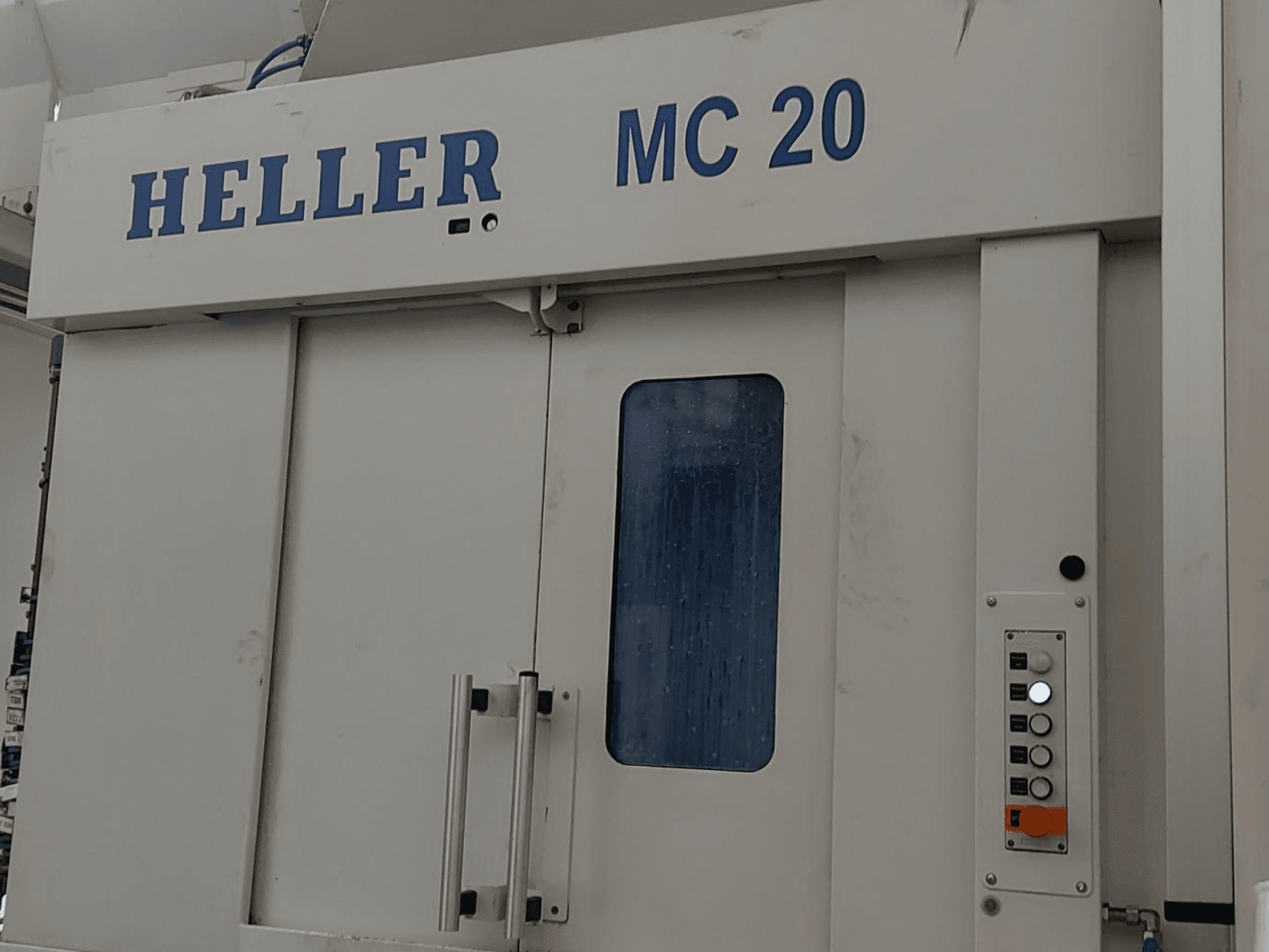 Frontvy av HELLER MC 20 horisontell bearbetningscenter med kontrollpanel och frontfönster.