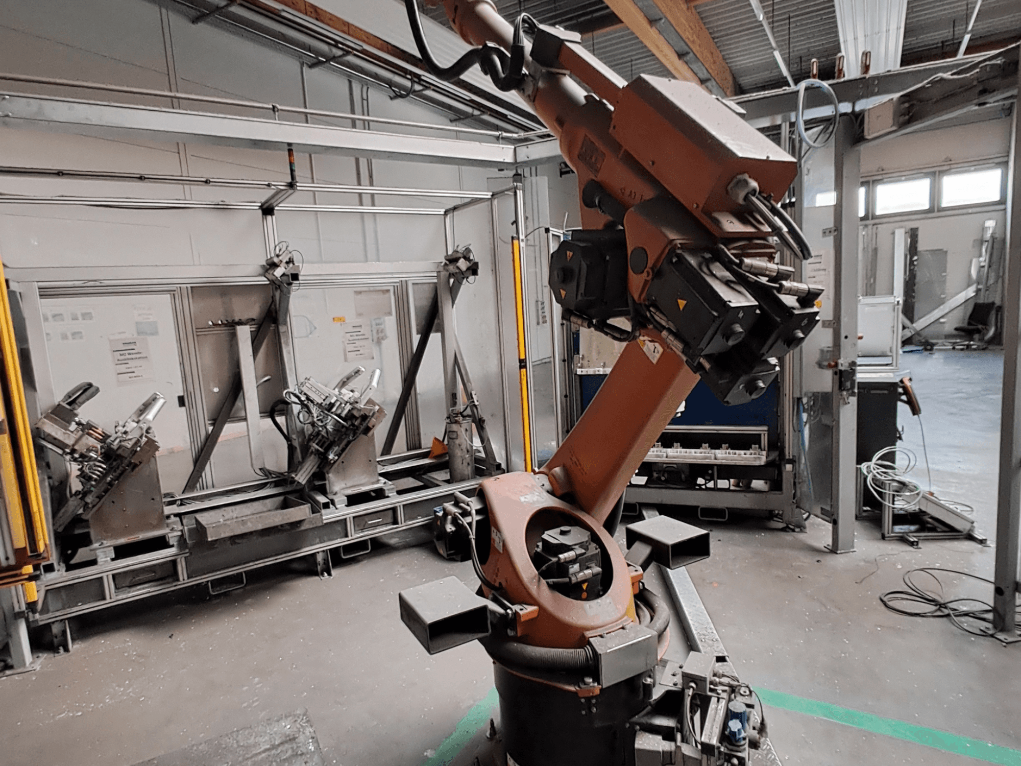Robotarmen KUKA KR 30L16-2 i en industriell miljö, sett från sidan, där armens leder och gripverktyg syns tydligt.