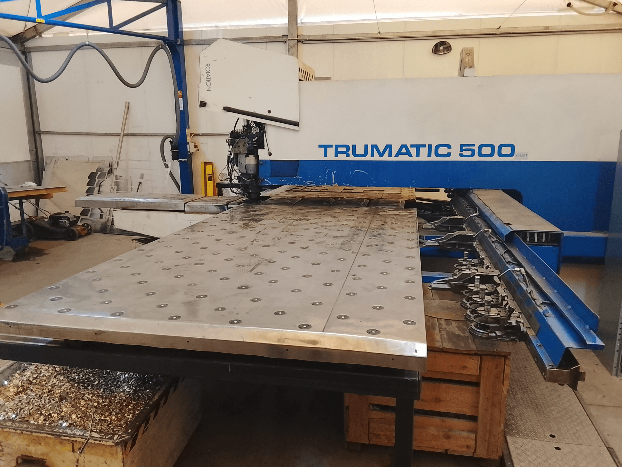 CNC-maskin Trumatic 500, vy uppifrån, med stort skärbord för metallbearbetning med monterade verktyg och spånor under.