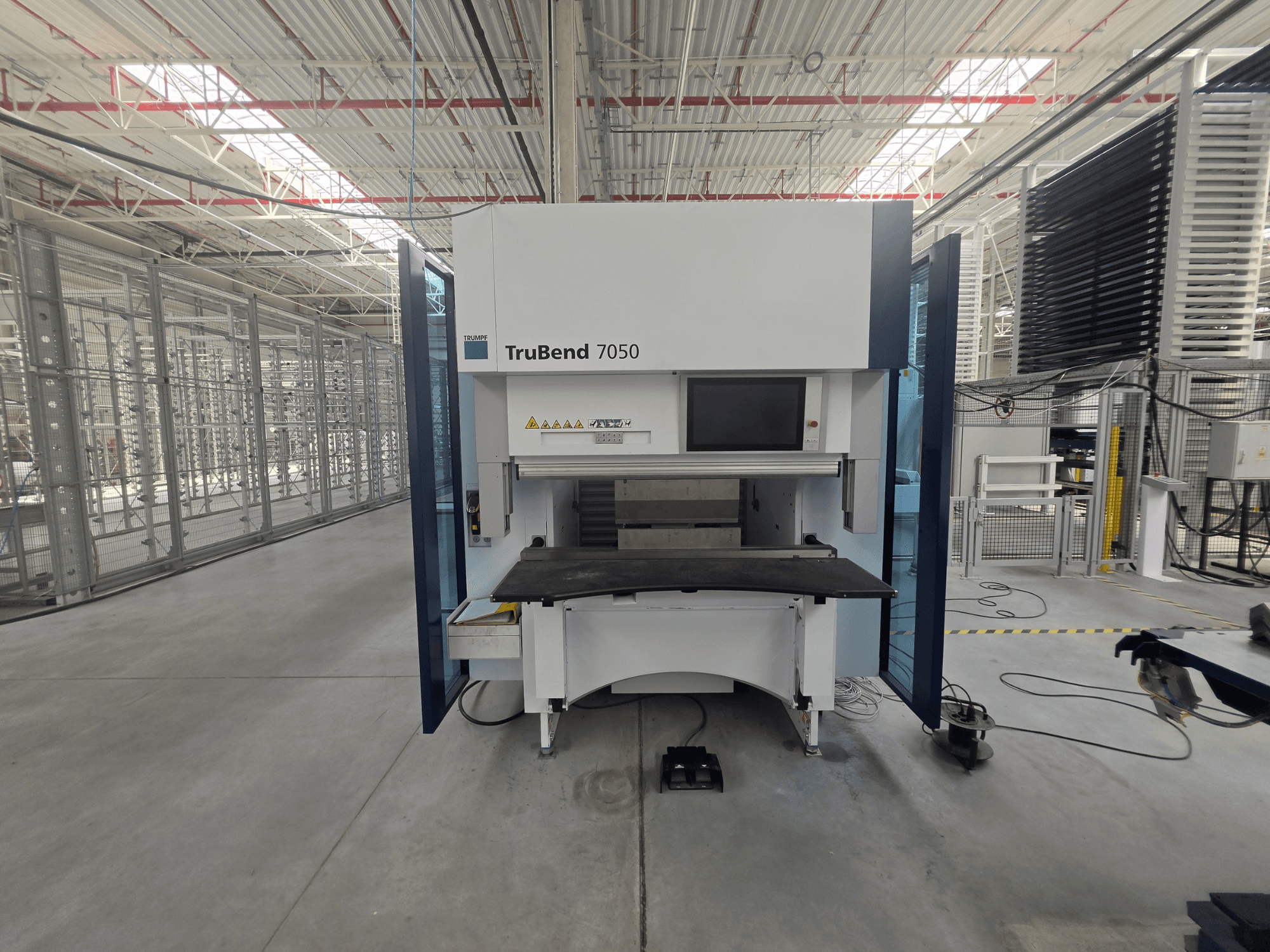 Framifrånbild av TRUMPF TruBend 7050 kantpress, där man ser kontrollpanelen och arbetsbordet i en väl upplyst industrimiljö.