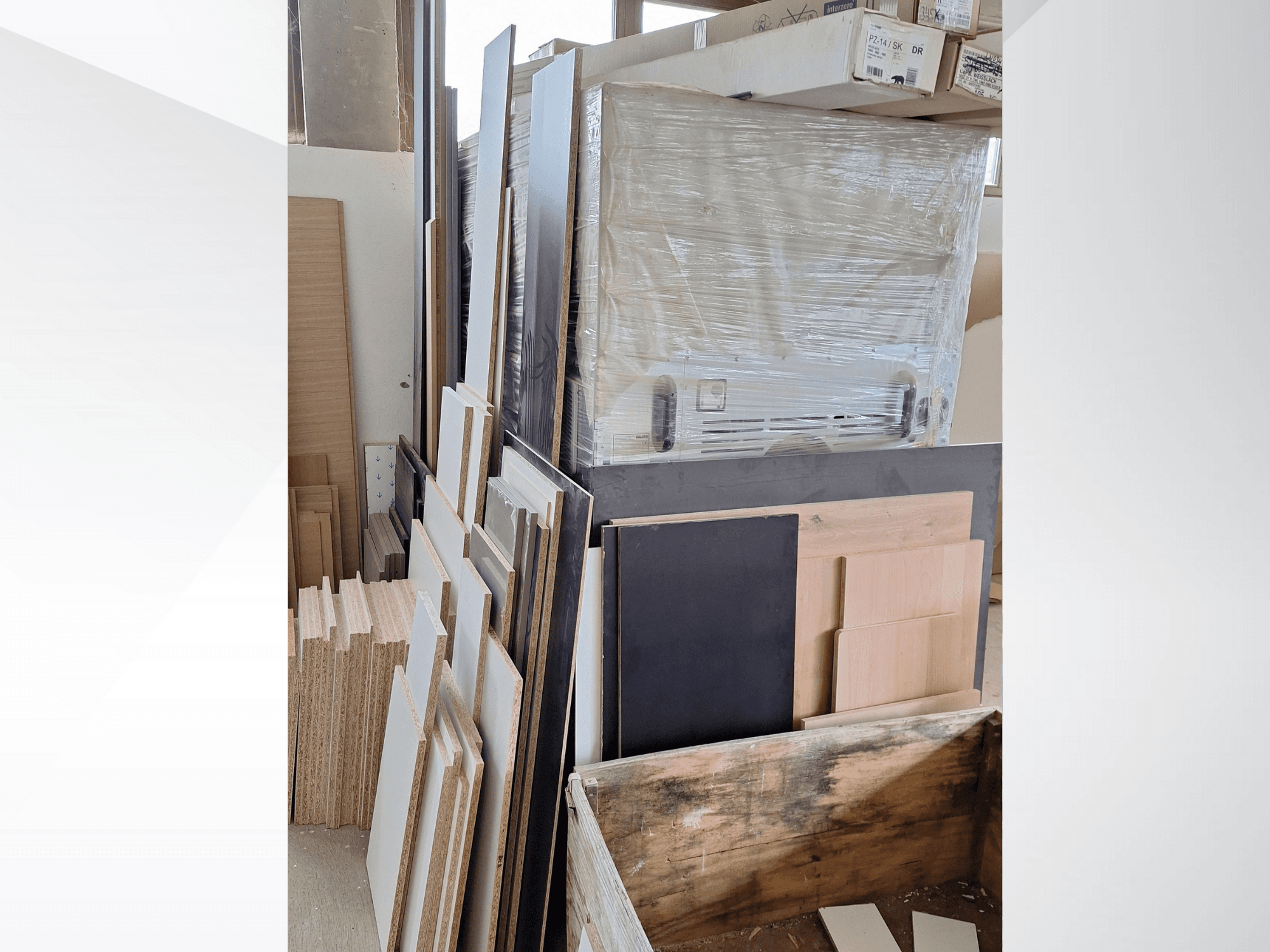 Olika plywoodpaneler och brädor staplade på varandra med olika ytbehandlingar; vy framifrån av material i en verkstadsmiljö.