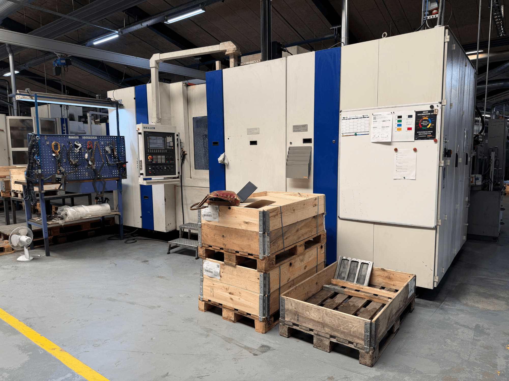 HORIZONTAL MACHINECENTER HELLER MCH 250 i verkstad, sidovy med träpallar och verktygshylla synliga.