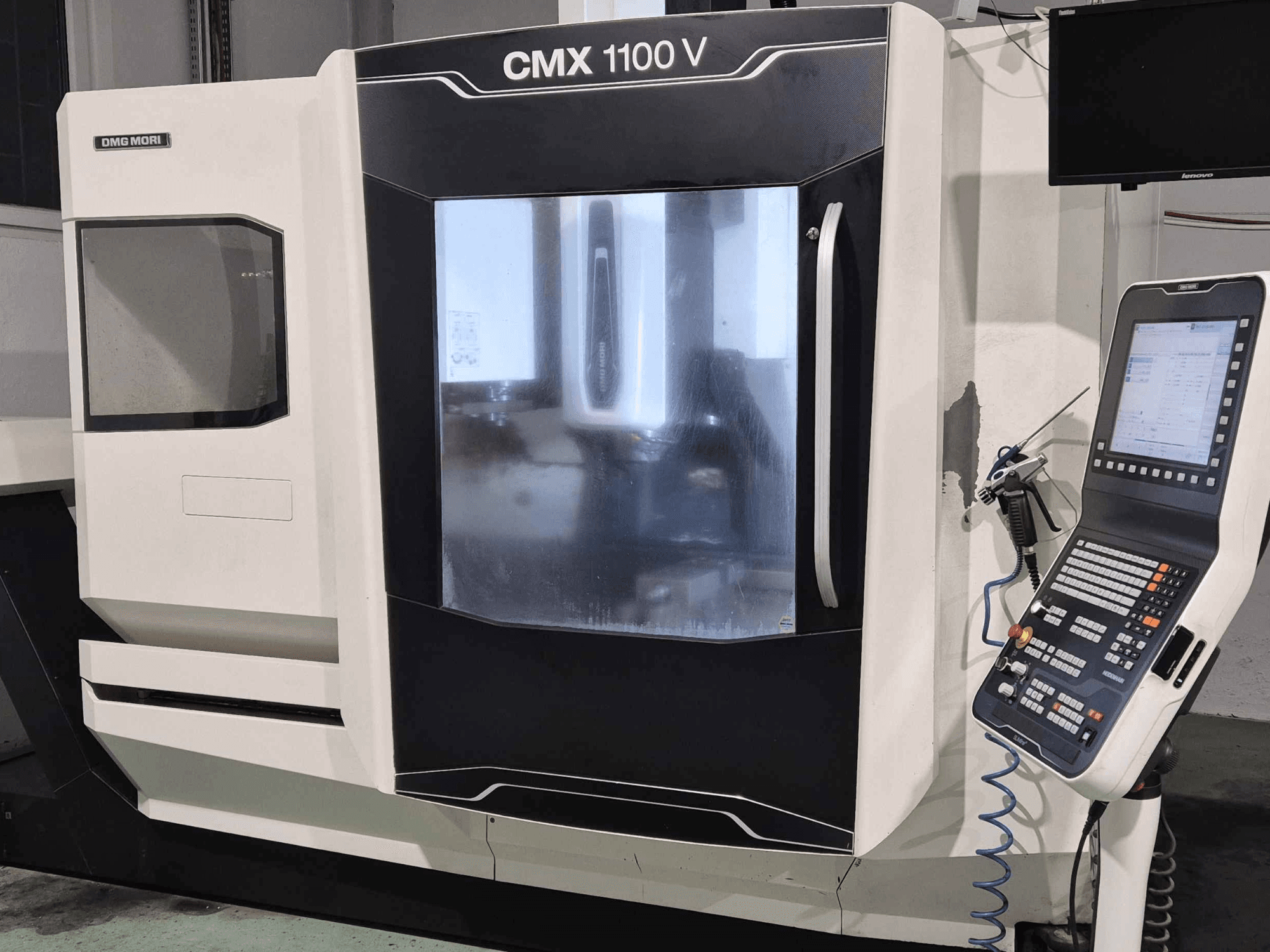 DMG Mori CMX 1100 V, CNC-maskinens framsida med kontrollpanel, digital display och kylmedelsinställning synliga.