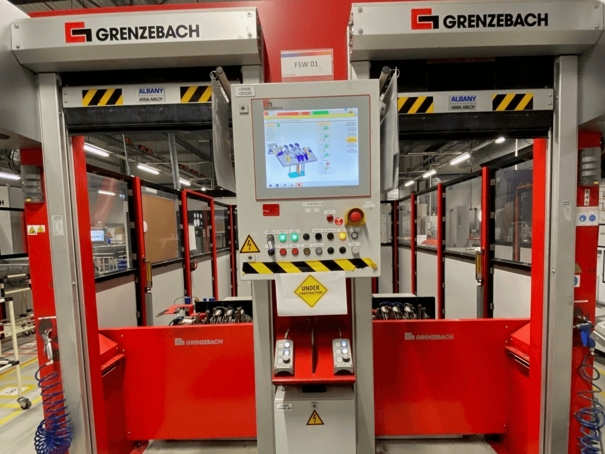 Framifrån sett på GRENZEBACH FSW GenRob 01-robotarmen, med en kontrollpanel som har en pekskärm och olika funktionsknappar.