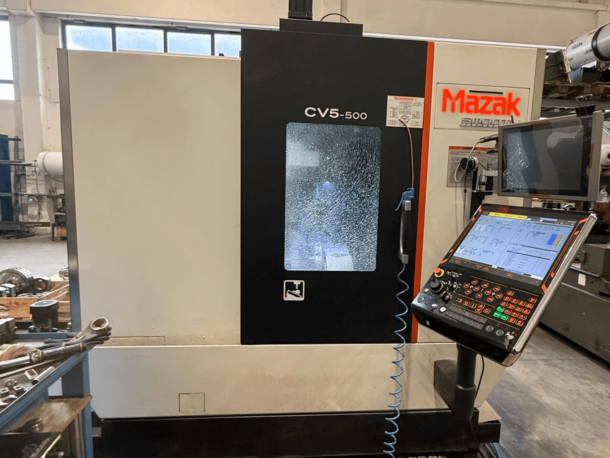 Mazak CV5-500 vertikalt bearbetningscenter, framifrån med kontrollpanel och display, visar driftsinställningar och gränssnitt.