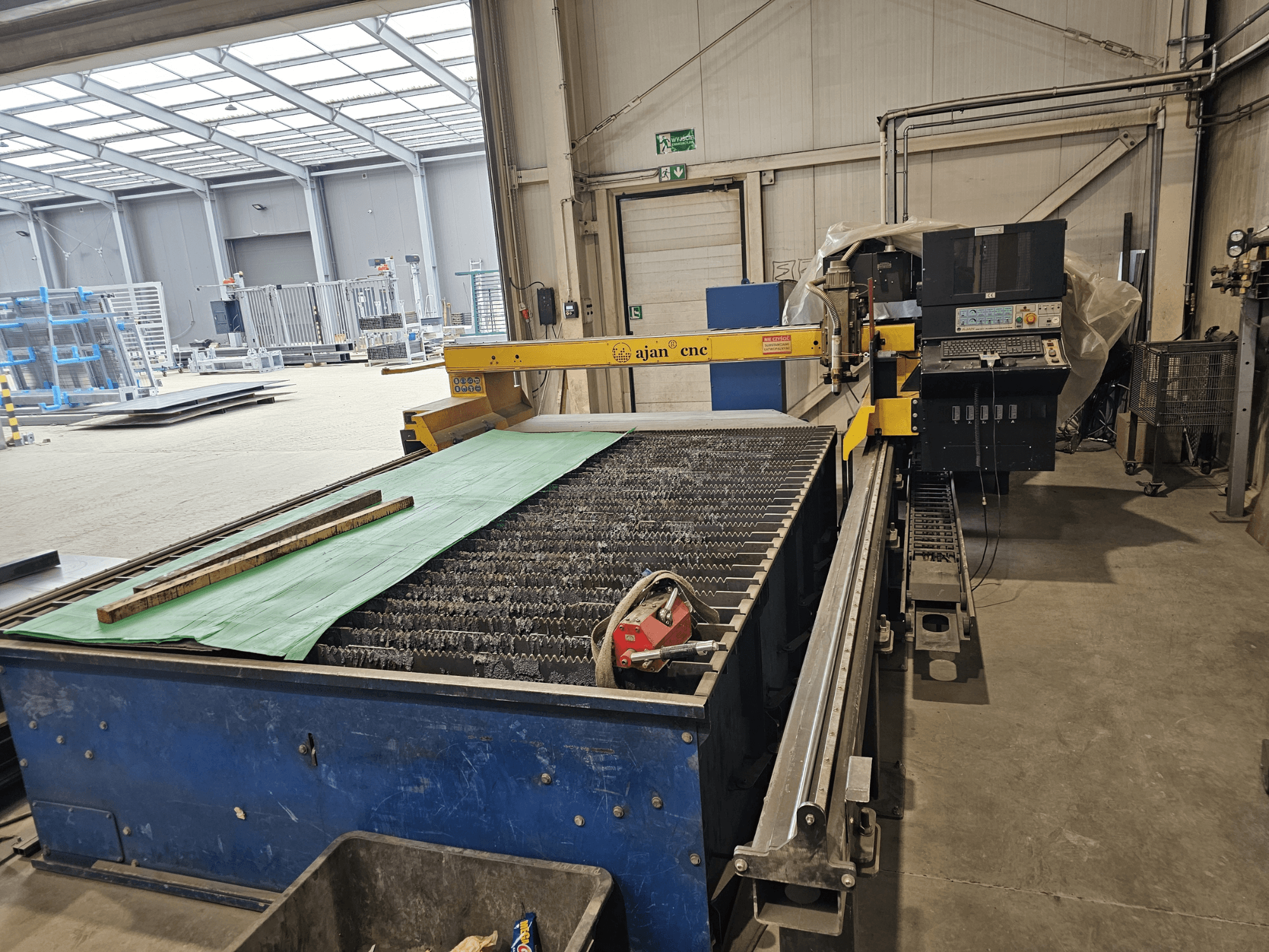 AJAN PP16011 Automatisk plasmaskärmaskin i sidovy, med skärbord och kontrollpanel, placerad i en verkstadsmiljö.