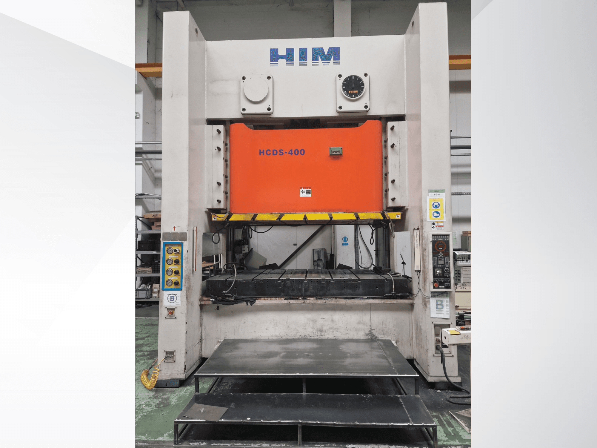 Framifrån sett: den mekaniska stanspressen HIM HWAIL PRESS HCDS-400 med en orange stansplatta och kontrollpanel.