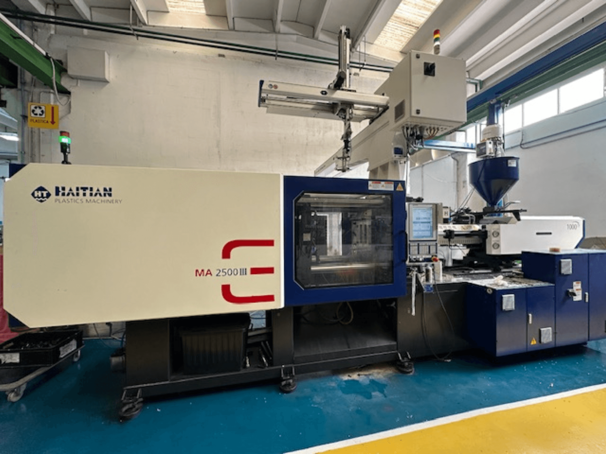 Hydraulisk formsprutningsmaskin MA 2500 III från Haiti, framifrån med kontrollpanel och behållare.