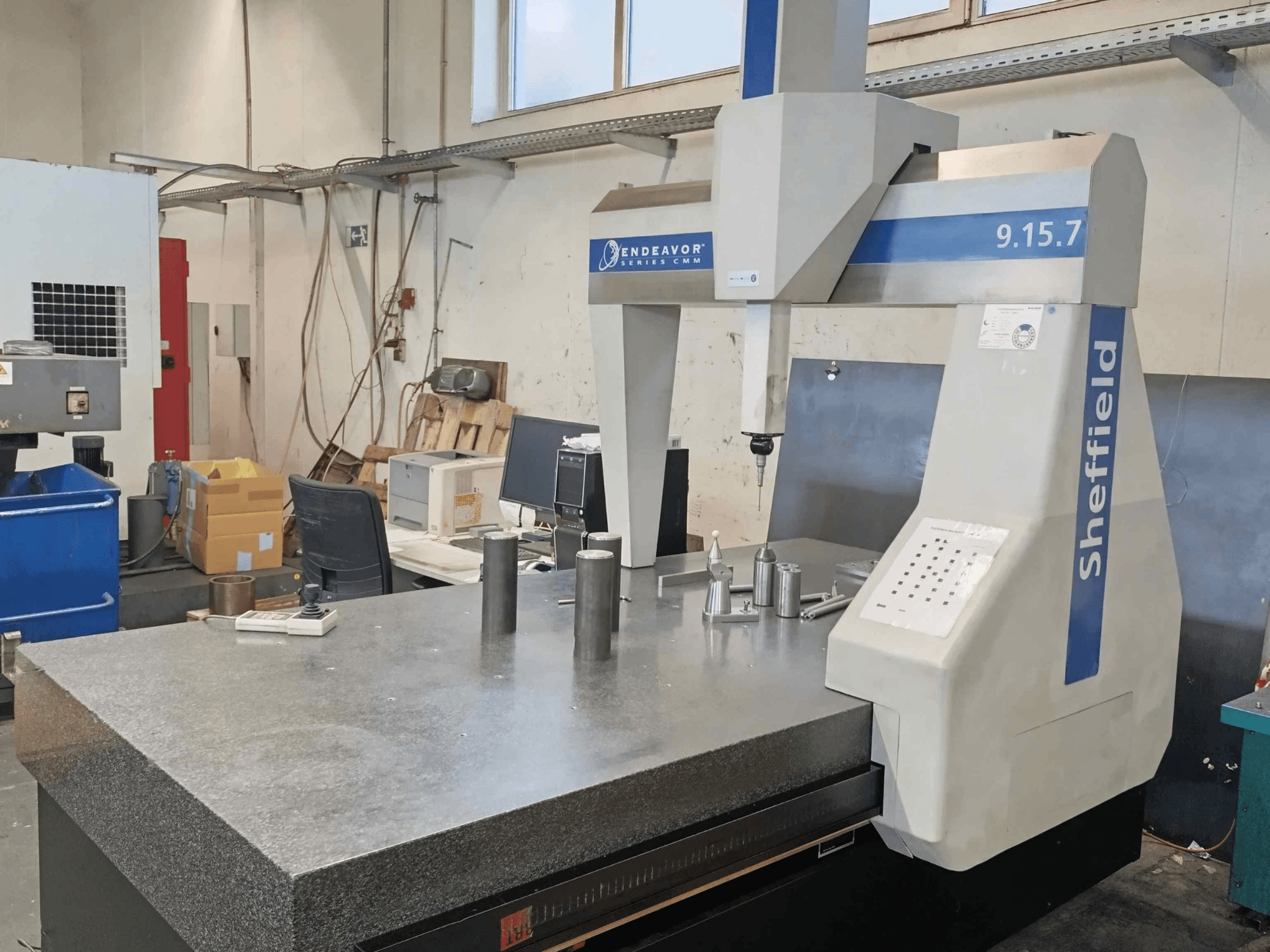 Koordinatmätmaskin Sheffield Endeavor 9.15.7 i en verkstad med ett granitbord och metalliska arbetsstycken.
