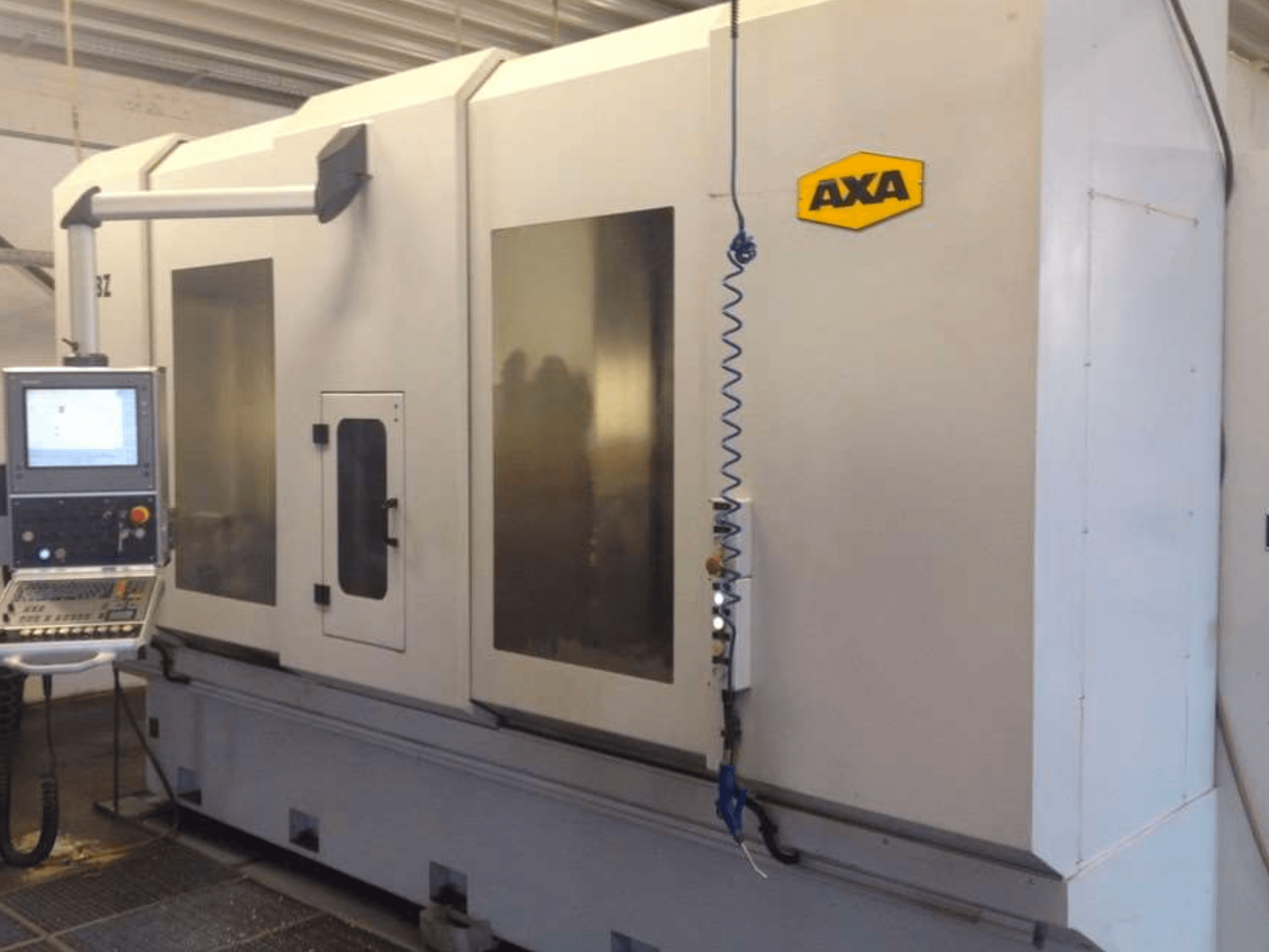 AXA DBZ vertikal fleroperationsmaskin sedd framifrån, med kontrollpanel och stora genomskinliga säkerhetsfönster.
