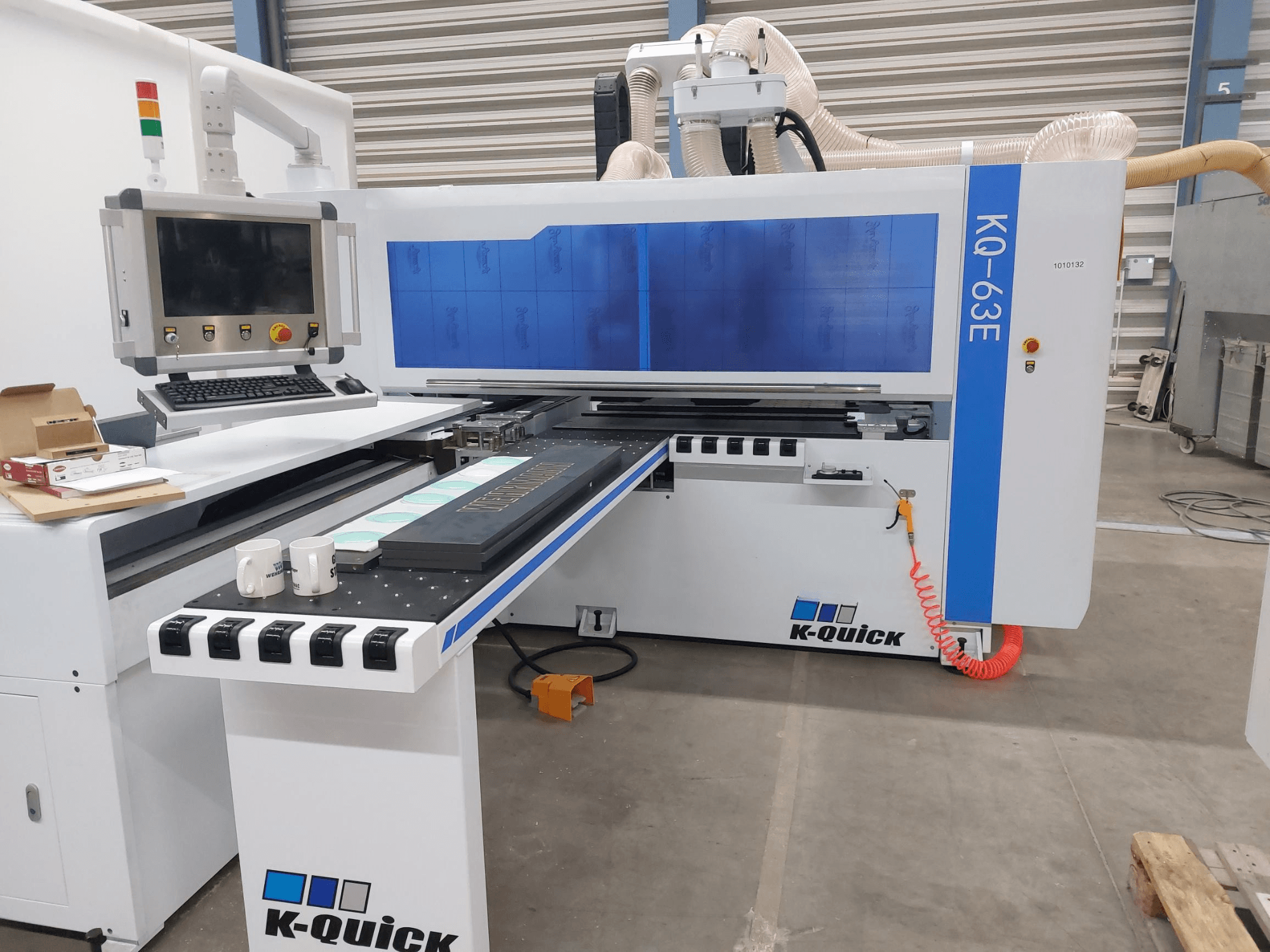 CNC-maskinen K-Quick KQ-63E sedd framifrån, med kontrollpanel, planbädd och synlig verktygsplacering.