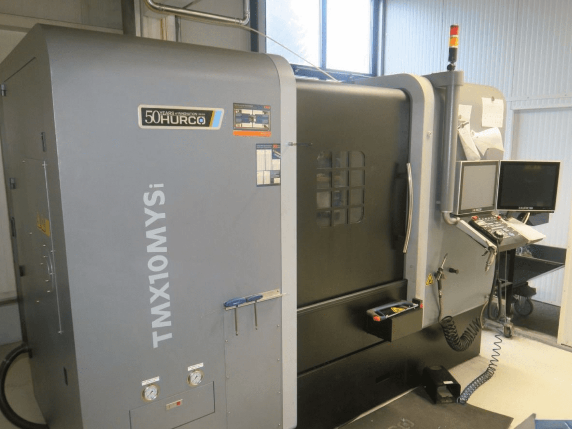 Hurco TMX10MYSi CNC-maskin i sidovy; kontrollpanel, nödljus och mätare visas.