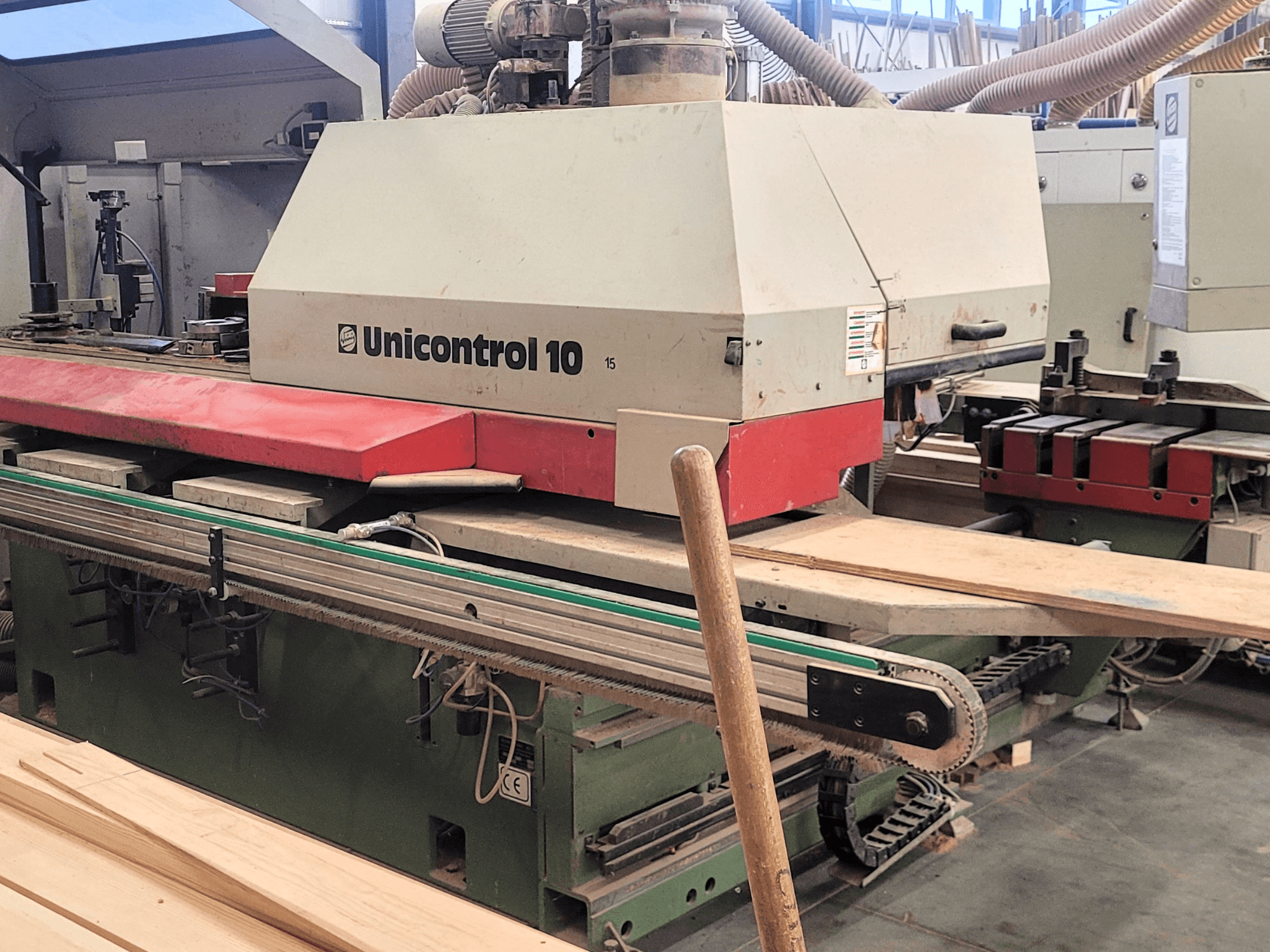 CNC-bearbetningscenter Unicontrol 10 av WEINIG/DIMTER, framifrån med träskivor och utrustning i en verkstadsmiljö.