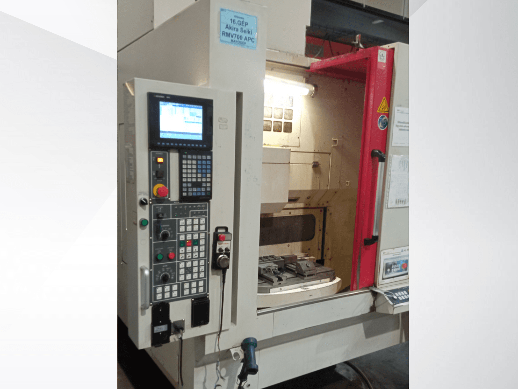 Akira Seiki RMV 700 APC vertikal fleroperationsmaskin framifrån, med digital kontrollpanel och arbetsyta med verktyg.
