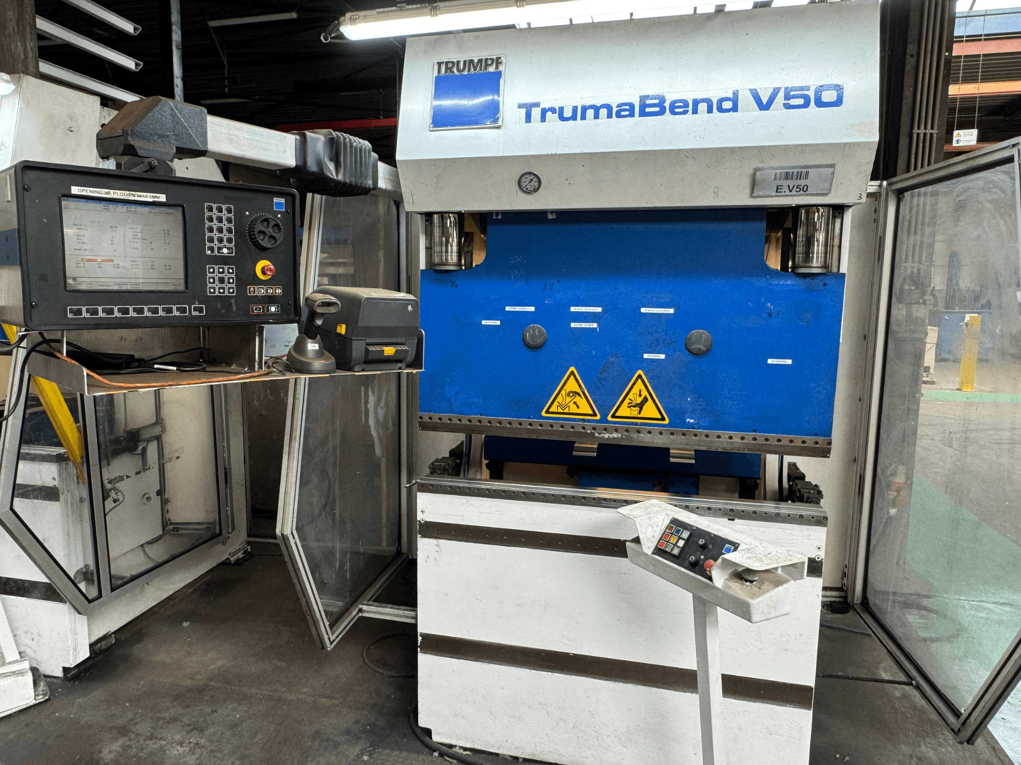 TRUMPF TrumaBend V50 kantpress framifrån, med kontrollpanel, säkerhetsvarningar och en tydlig blåvit design.