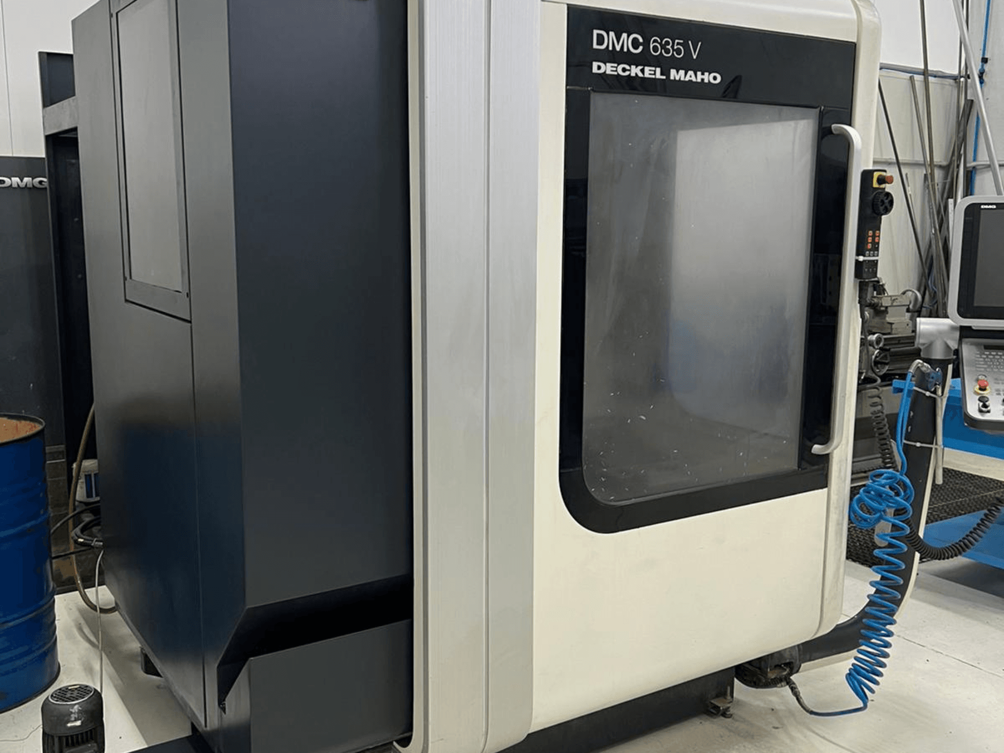 DMC 635 V fräsmaskin från Deckel Maho, sidovy som visar kontrollpanel och delvis öppen åtkomstdörr.