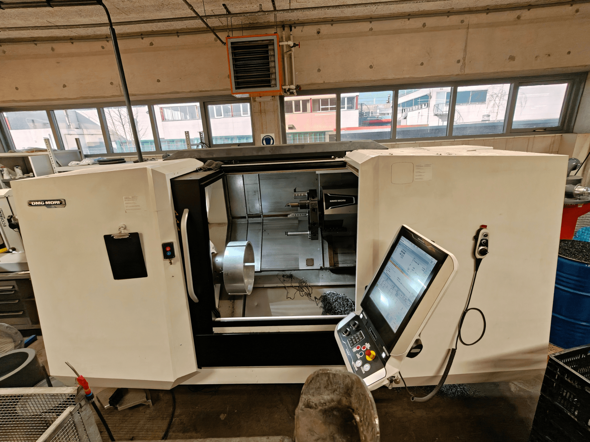 Frontvy av en DMG MORI CLX 550 horisontell svarv, som visar kontrollpanelen och det öppna arbetsområdet.