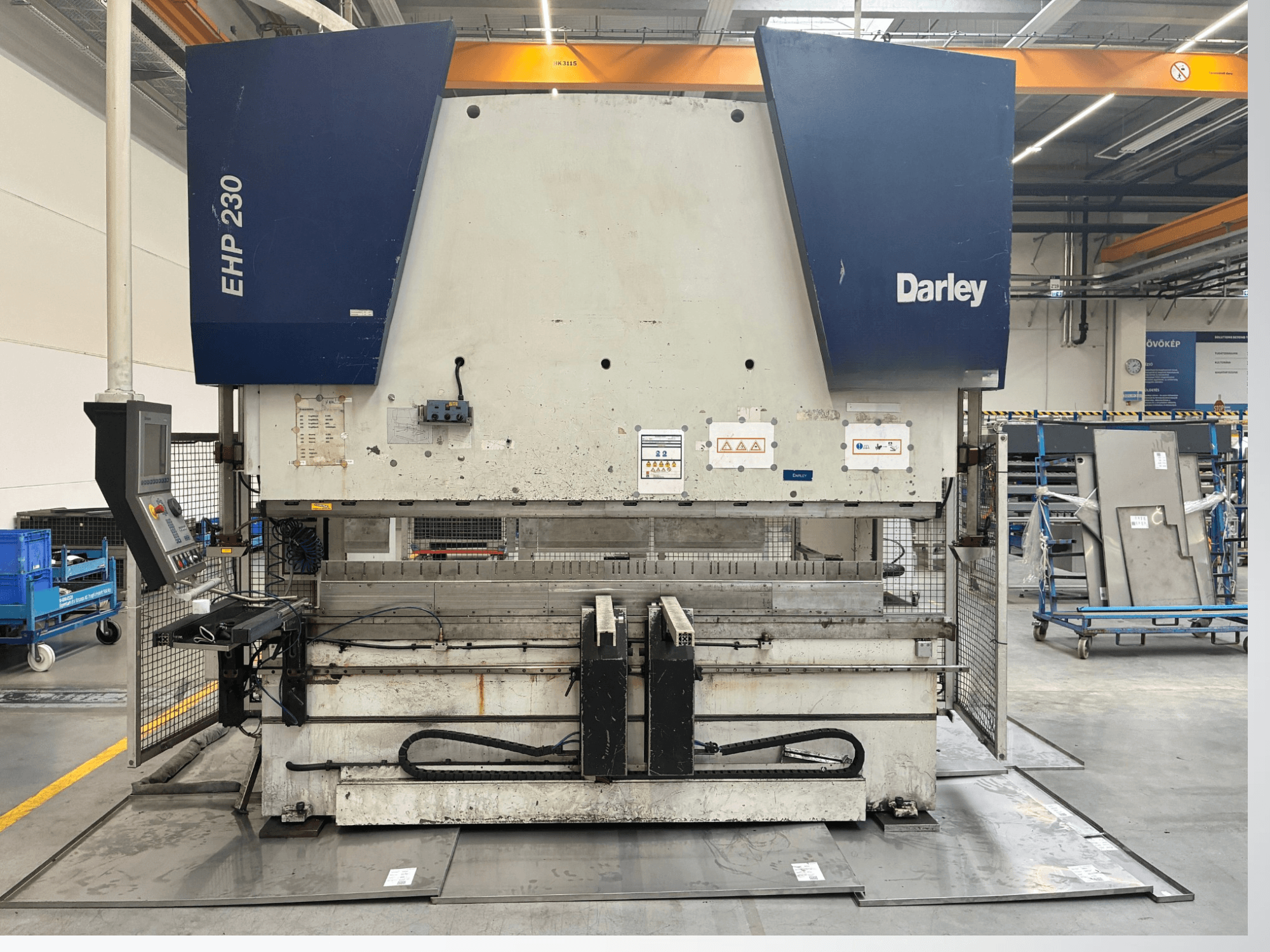 Hydraulisk press Darley EHP-LS 230.31/25, framifrån, med kontrollpanel och metallplåtar i närheten. Idealisk för industriella tillämpningar.