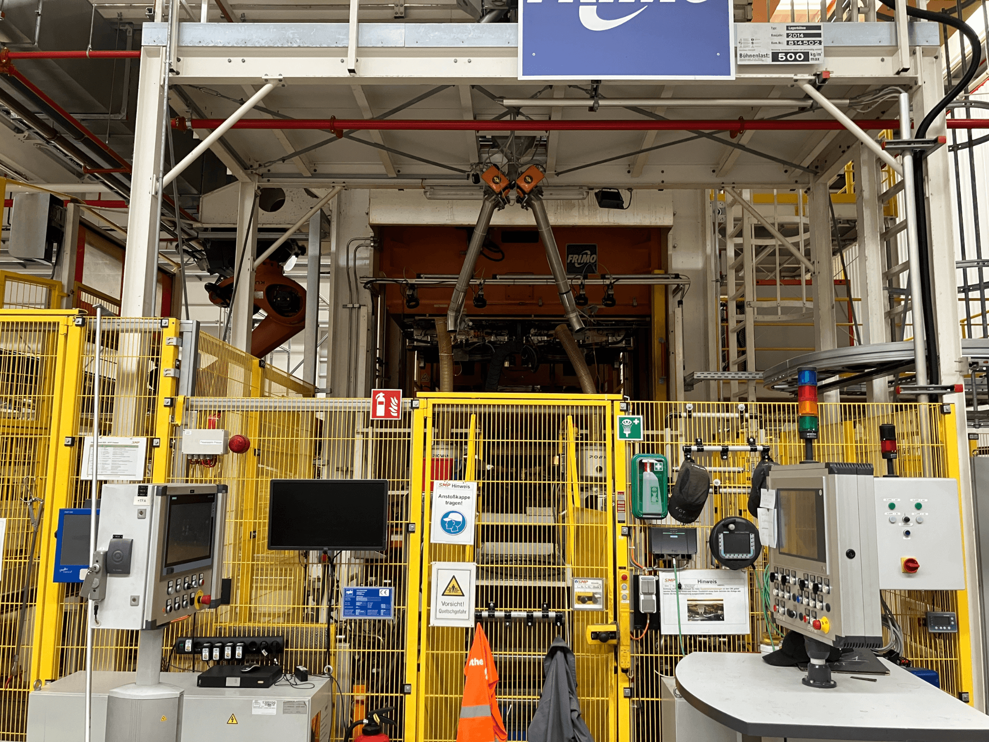 FRIMO NFPP Thermoforming Plant framifrån, med kontrollpaneler och säkerhetsstängsel i en väl upplyst industrimiljö.